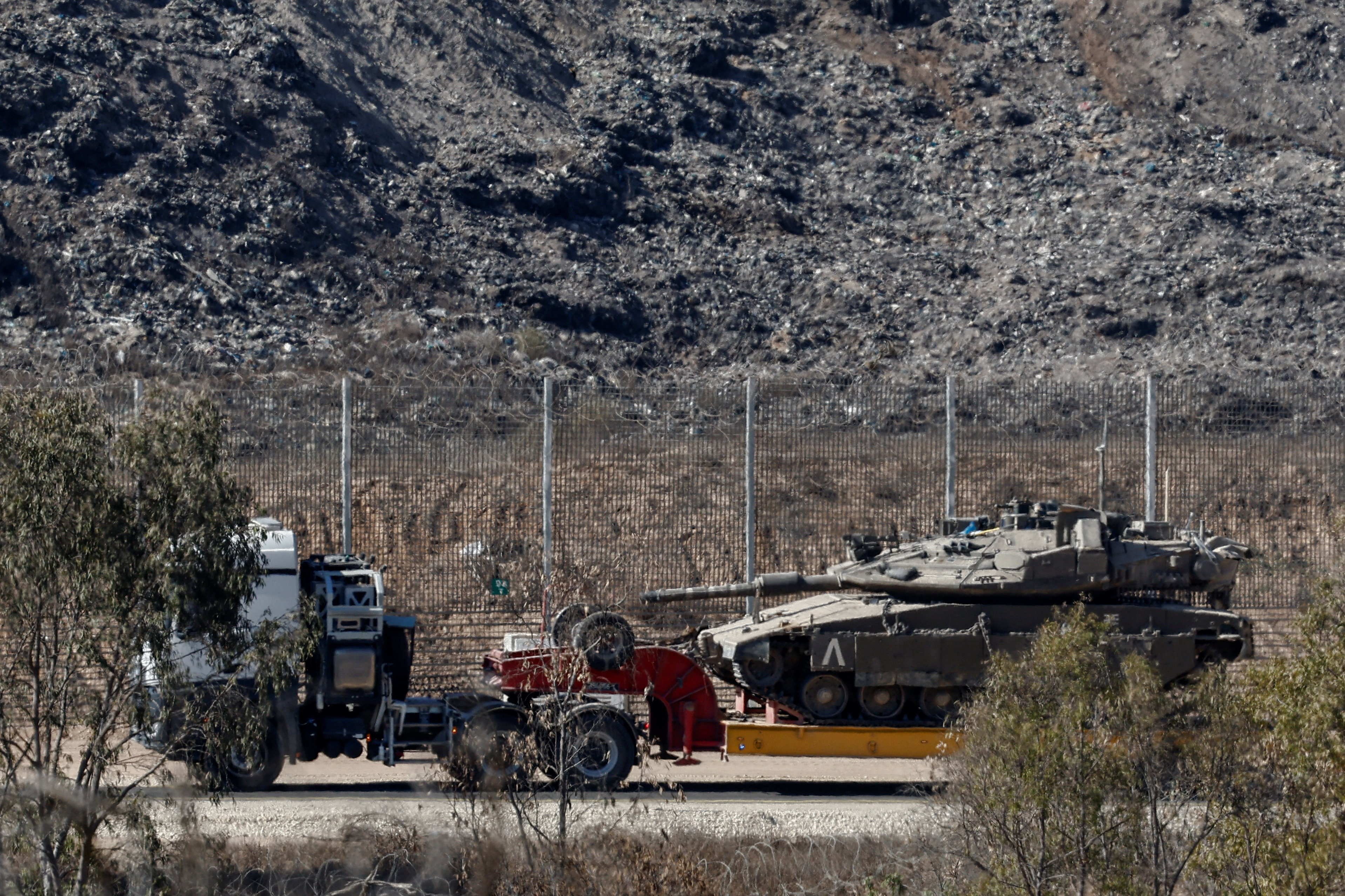 A truck transports a tank on the Israeli side of the border with Gaza, in Israel
