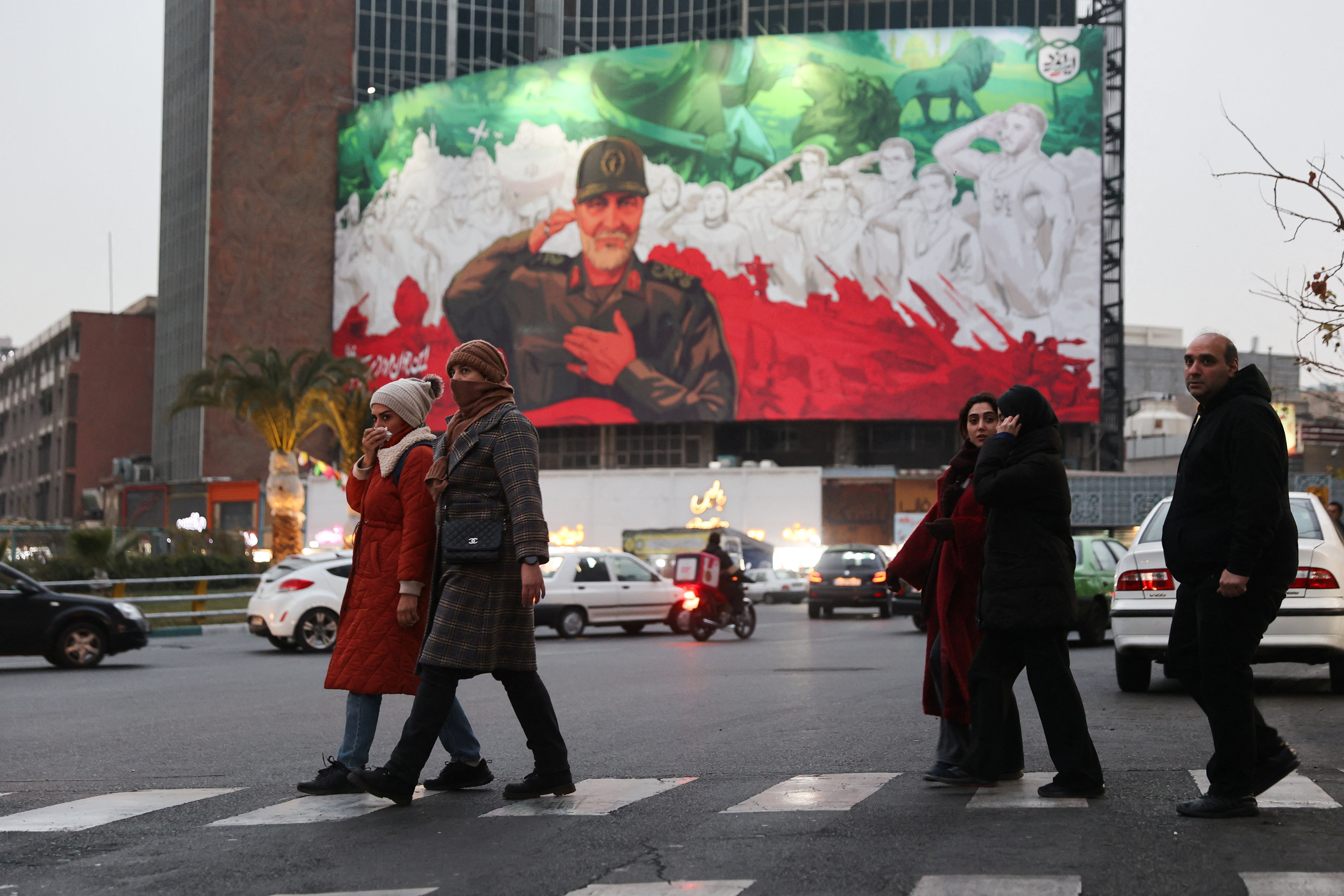 People walk on a street as protests erupt over the collapse of the currency's value in Tehran