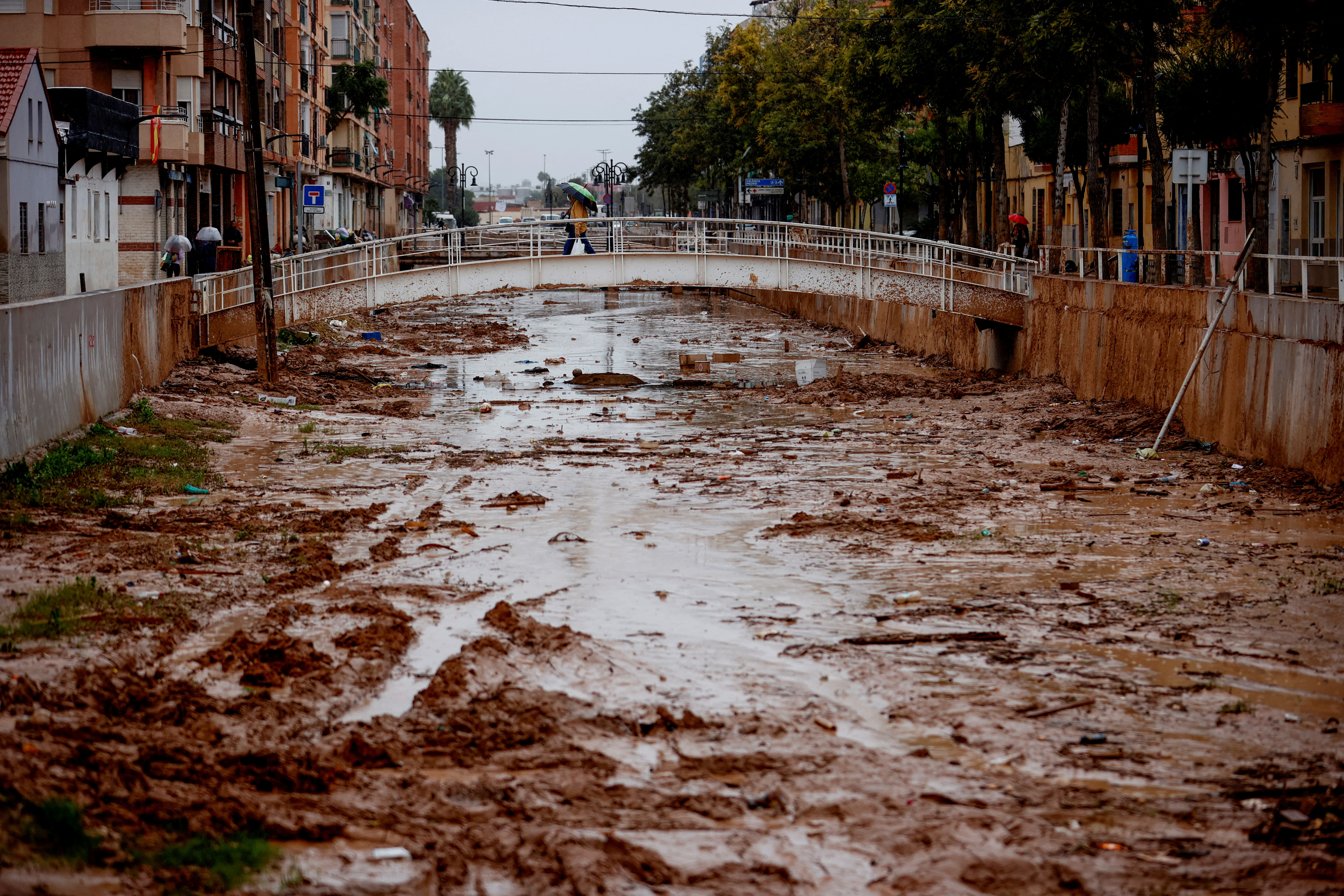 A person crosses the La Saleta ravine that recently overflowed due to heavy rainfall in Aldaia
