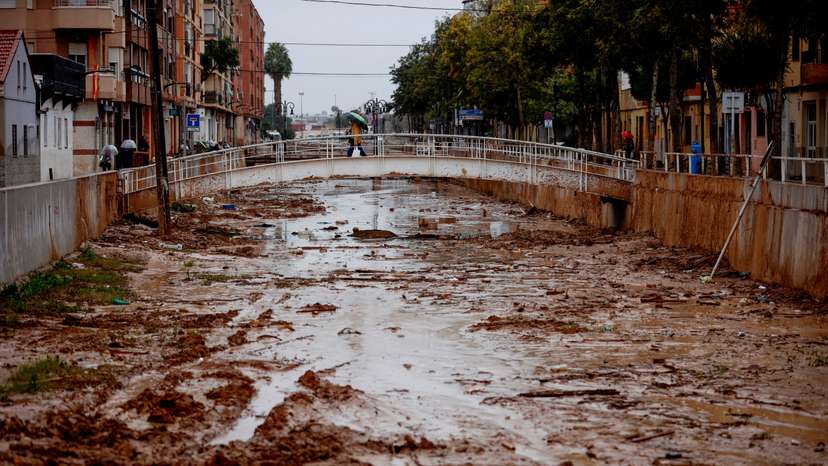 A person crosses the La Saleta ravine that recently overflowed due to heavy rainfall in Aldaia
