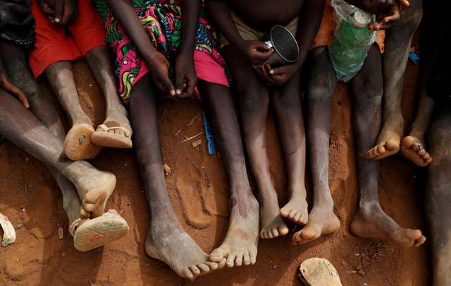 FILE PHOTO: FILE PHOTO: Internally displaced orphans from Kadugli gather to eat boiled leaves at an IDP camp in South Kordofan, Sudan