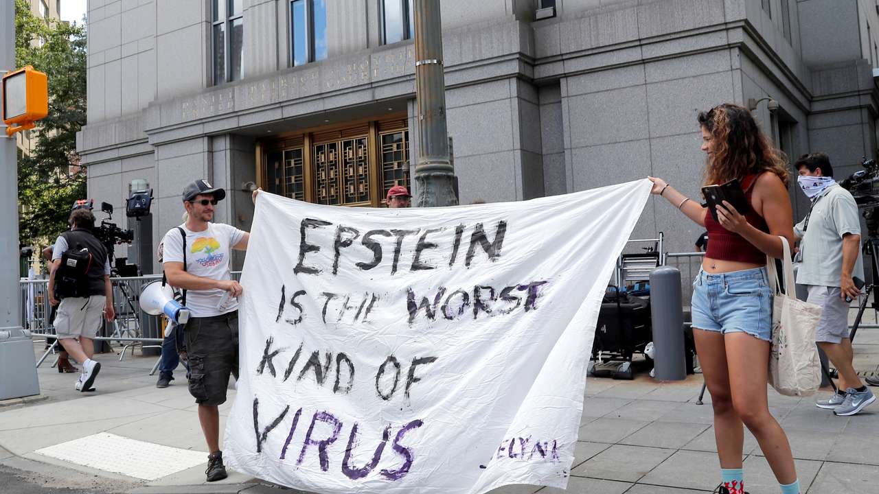 Protesters and members of the news media gather outside Manhattan Federal Court, during the arraignment hearing of Ghislaine Maxwell, in New York