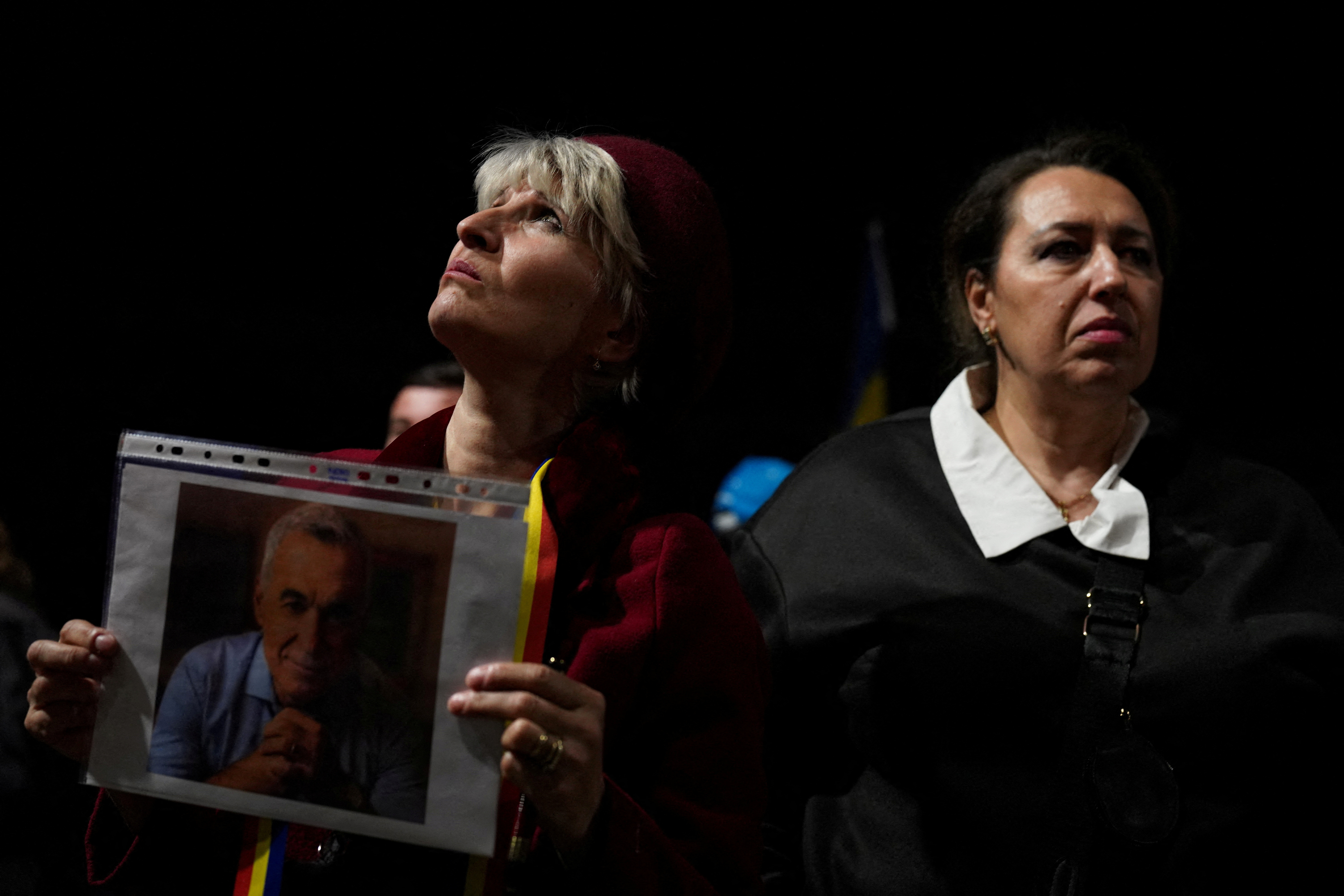 A supporters of far-right candidate Calin Georgescu holds a portrait of Calin Georgescu