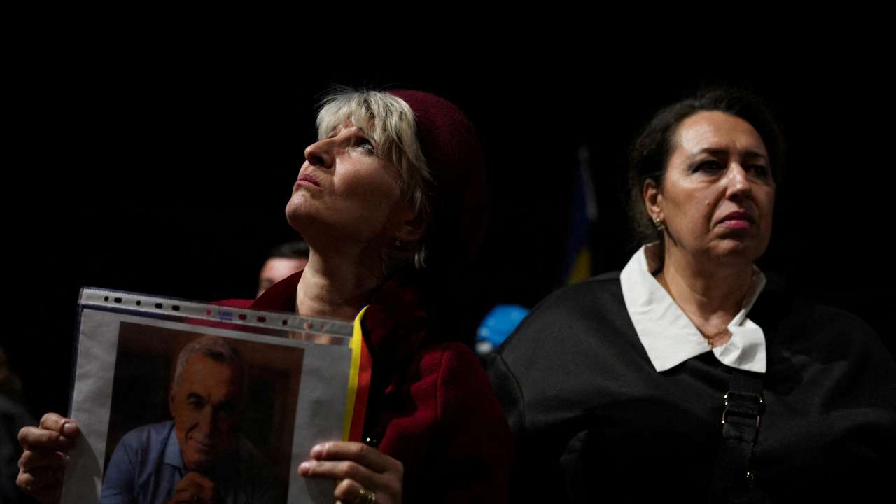 A supporters of far-right candidate Calin Georgescu holds a portrait of Calin Georgescu