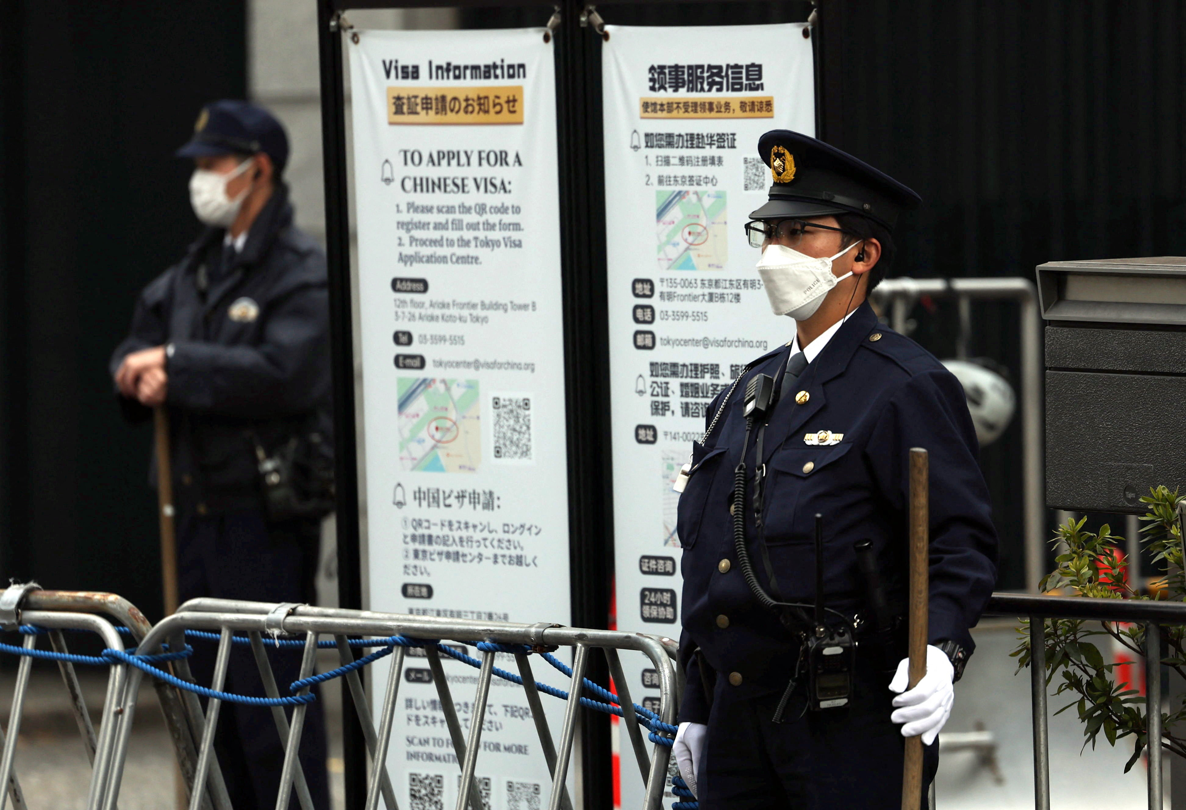 Japanese police officers stand guard at the entrance of the Chinese embassy in Tokyo