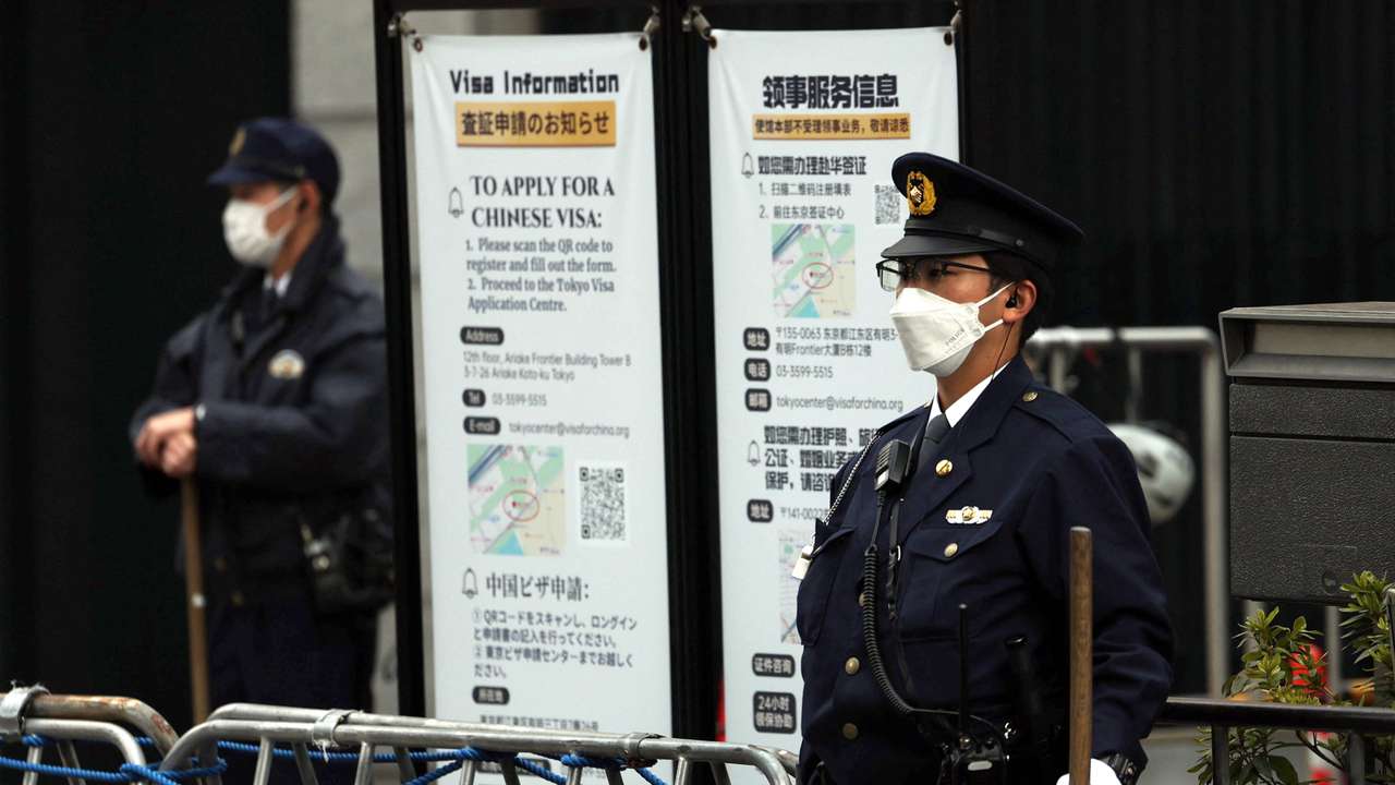 Japanese police officers stand guard at the entrance of the Chinese embassy in Tokyo