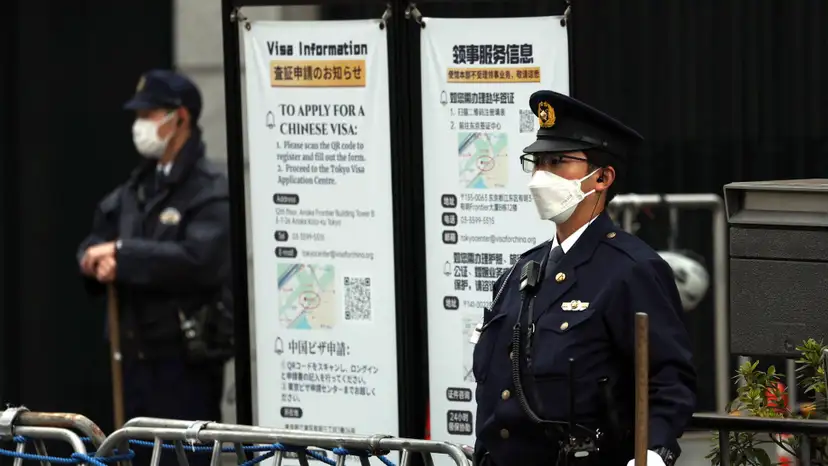 Japanese police officers stand guard at the entrance of the Chinese embassy in Tokyo