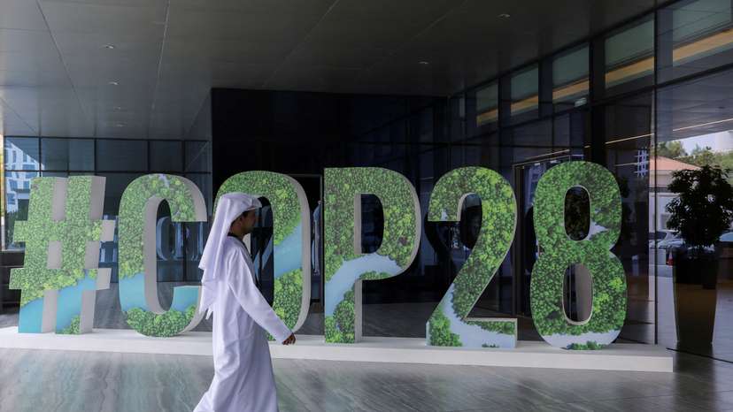 FILE PHOTO: A person walks past a "#COP28" sign during The Changemaker Majlis, a one-day CEO-level thought leadership workshop focused on climate action, in Abu Dhabi
