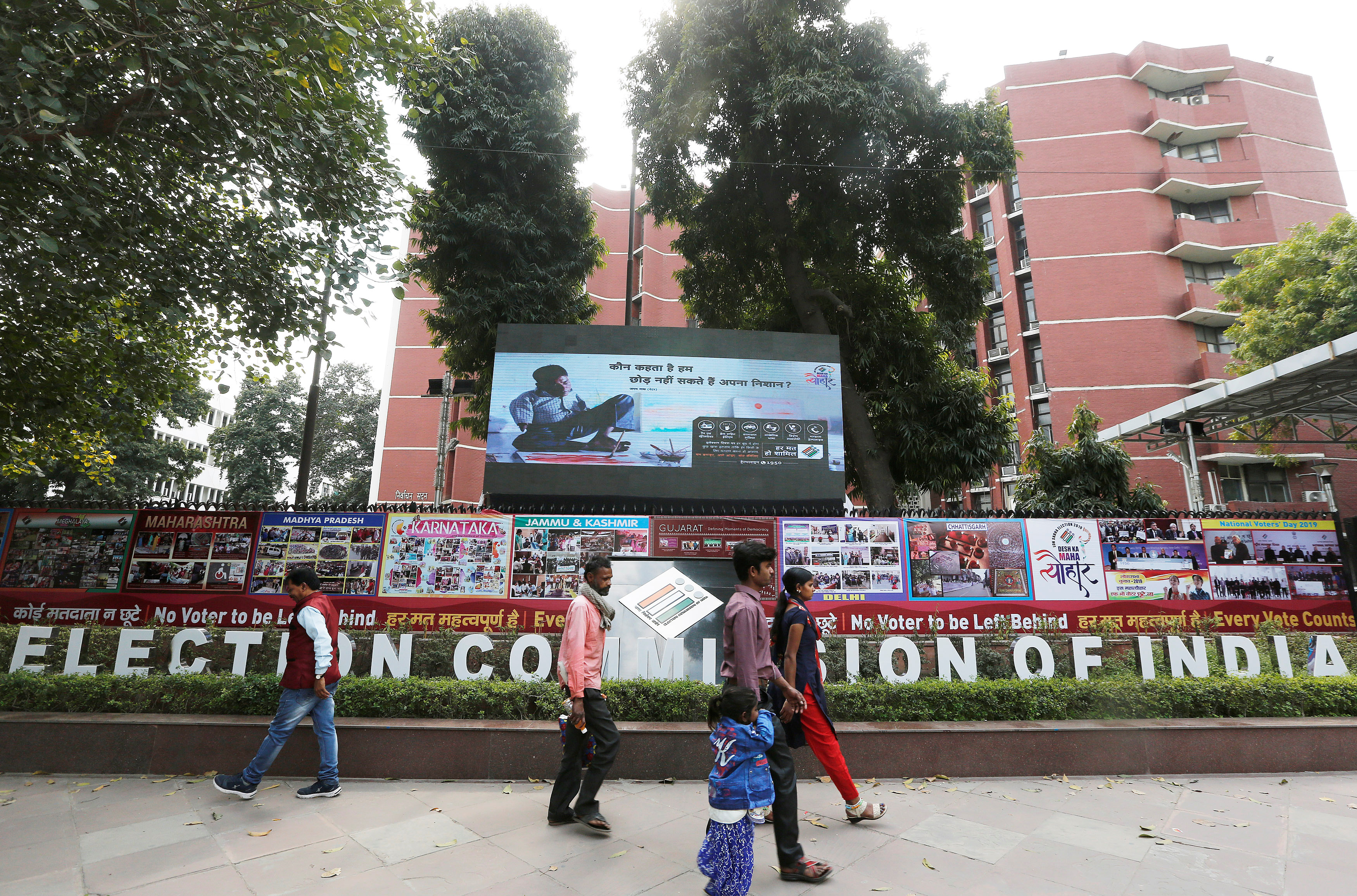 People walk past the Election Commission of India office building in New Delhi