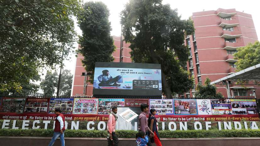 People walk past the Election Commission of India office building in New Delhi
