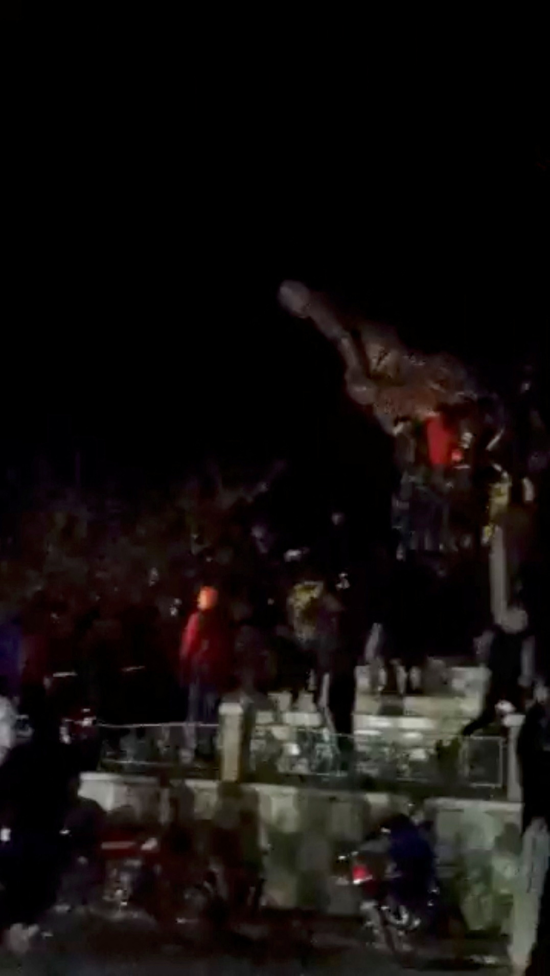 People demolish the statue of Syrian President Bashar al-Assad's father Hafez al-Assad, in Daraa