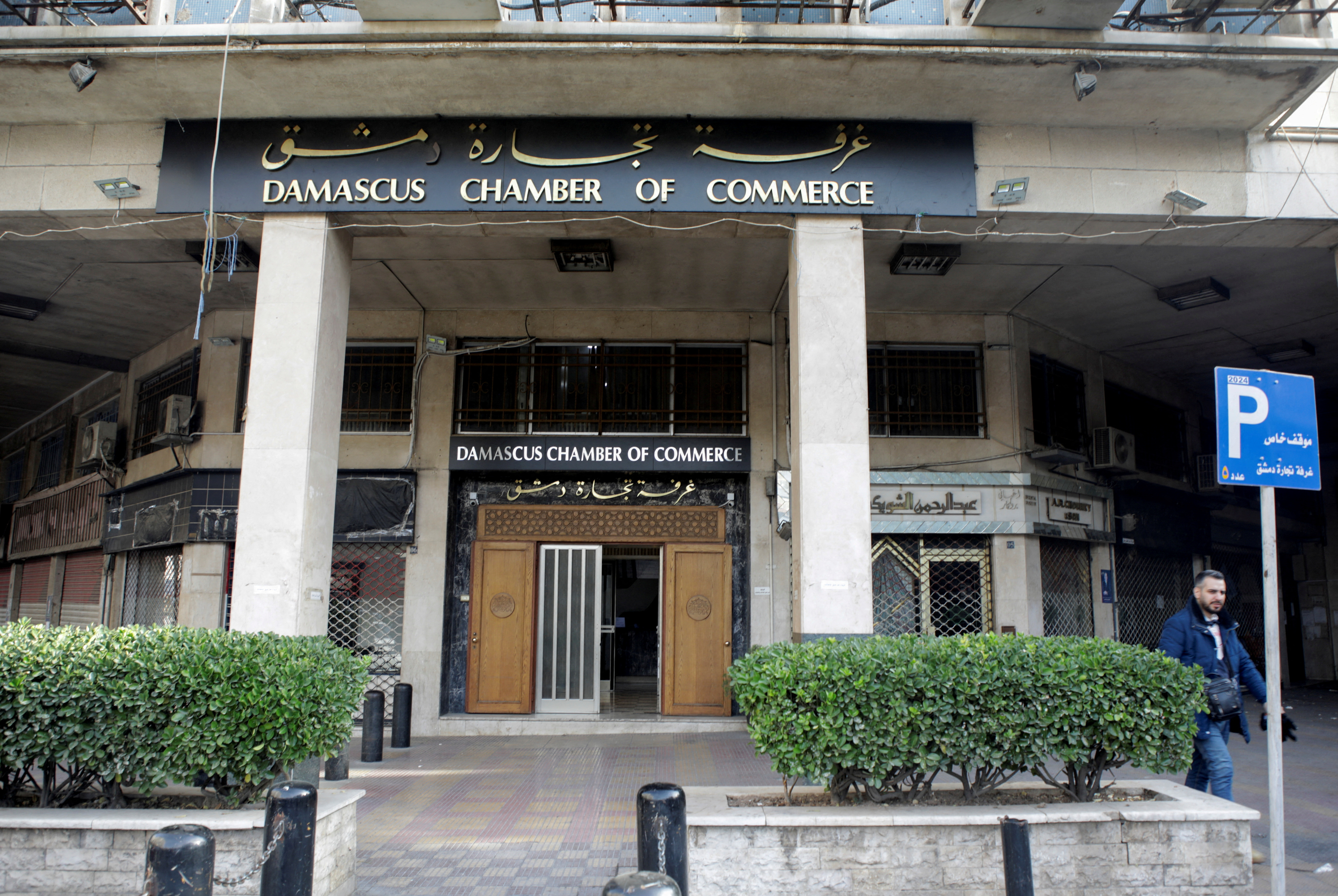 A man walks near the Damascus Chamber of Commerce in Damascus