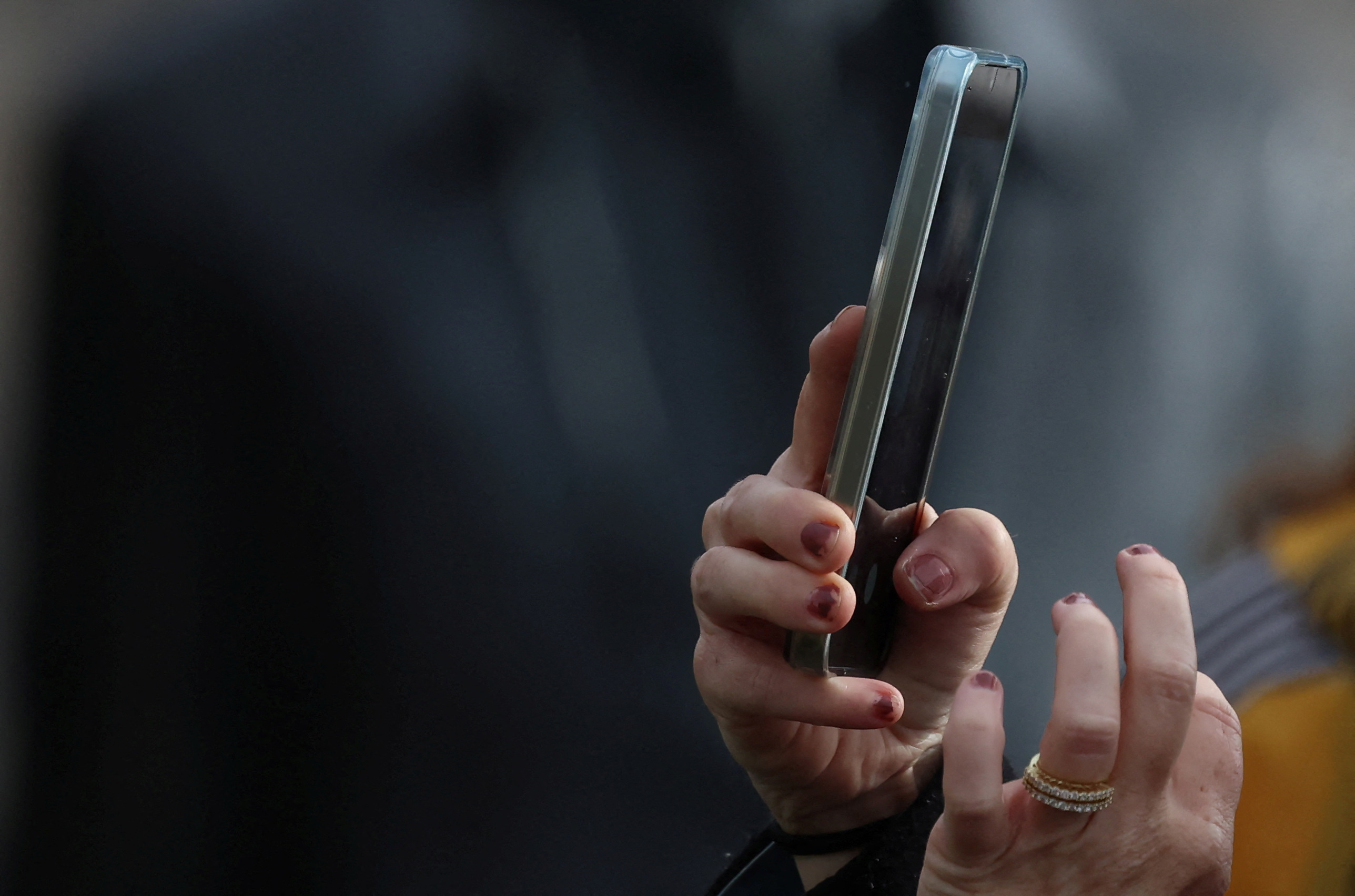A woman uses a smartphone to take a photograph in Liverpool