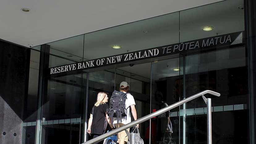 Two people walk towards the entrance of the Reserve Bank of New Zealand located in the New Zealand capital city of Wellington