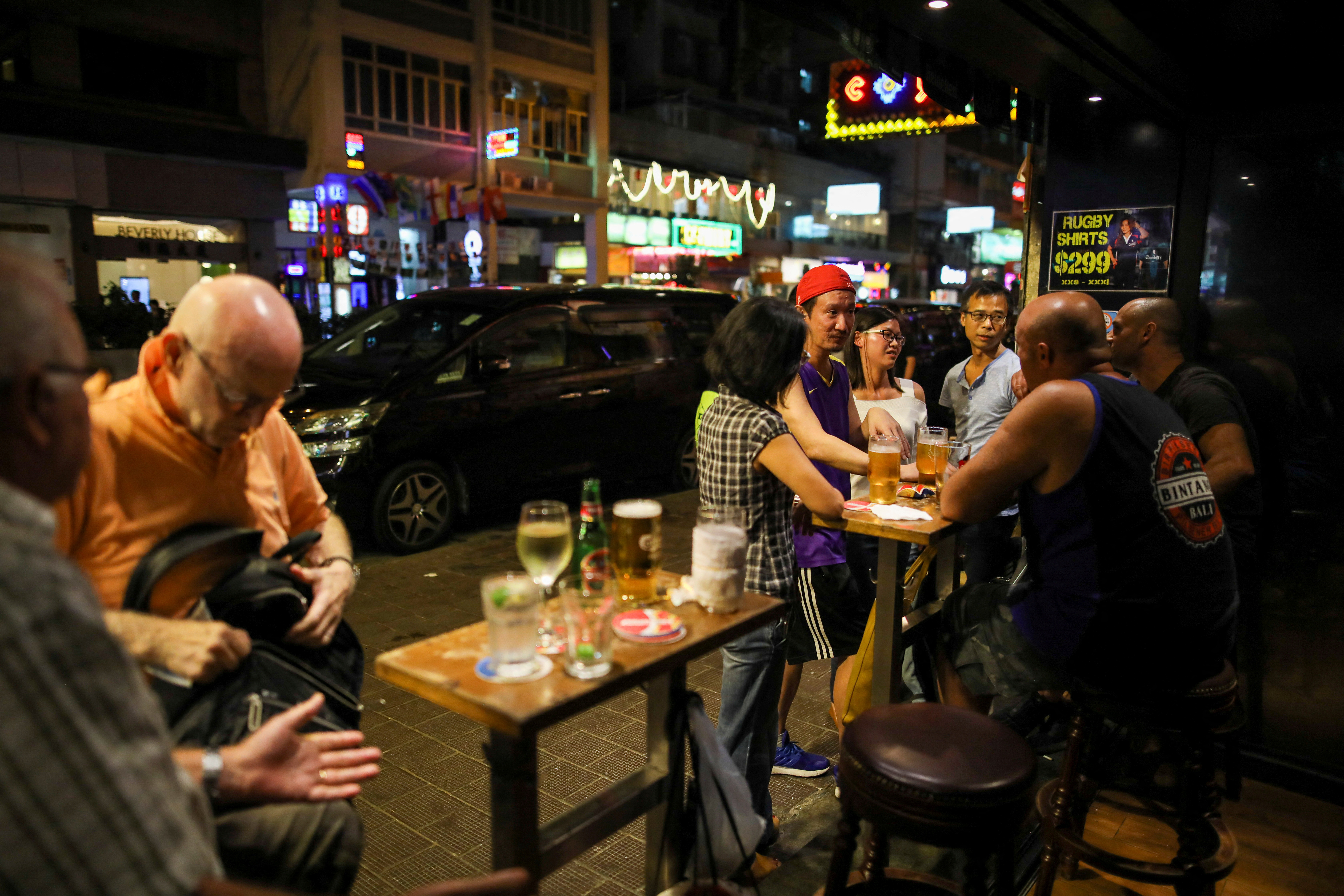 FILE PHOTO: People have a drink inside a bar in Hong Kong, China