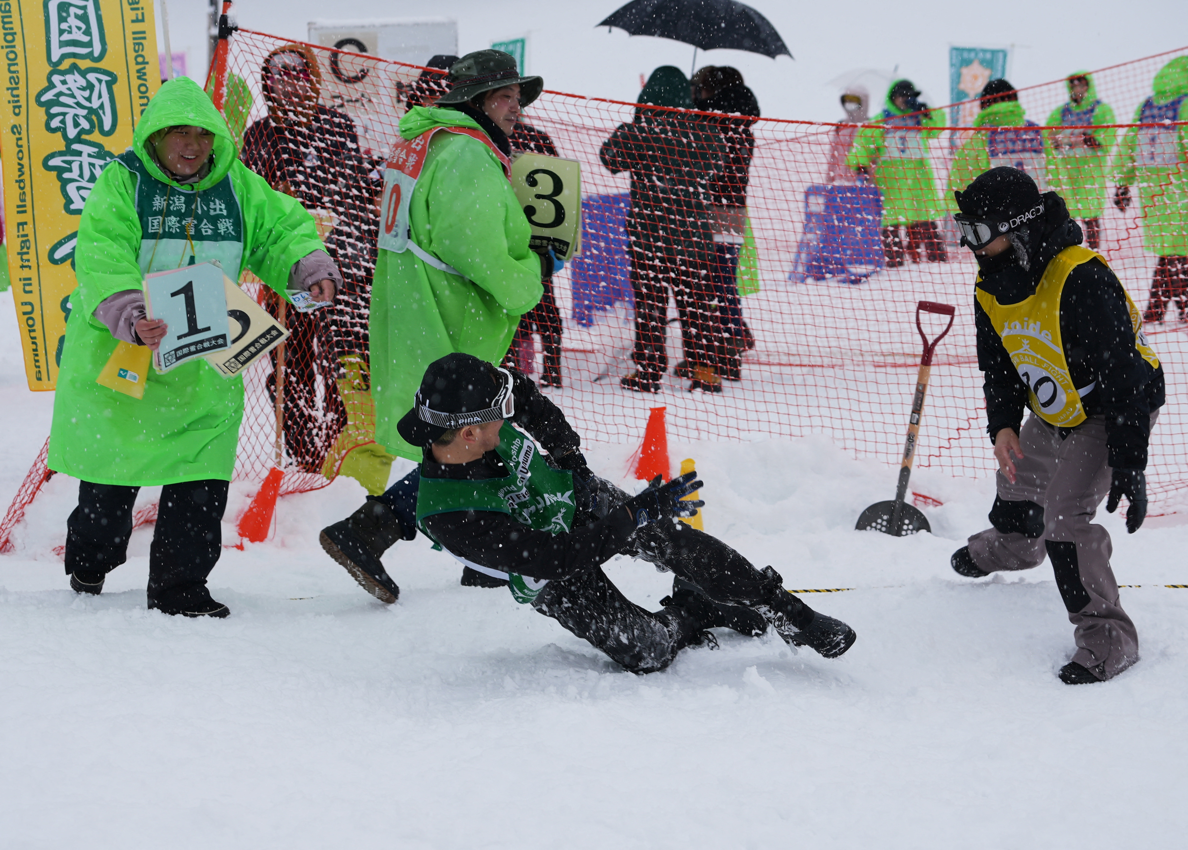 A man falls while throwing a snowball at the 35th Koide International Snowball Fight in Uonuma