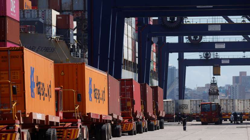Trucks deliver containers to be loaded onto a ship at the port in Durban