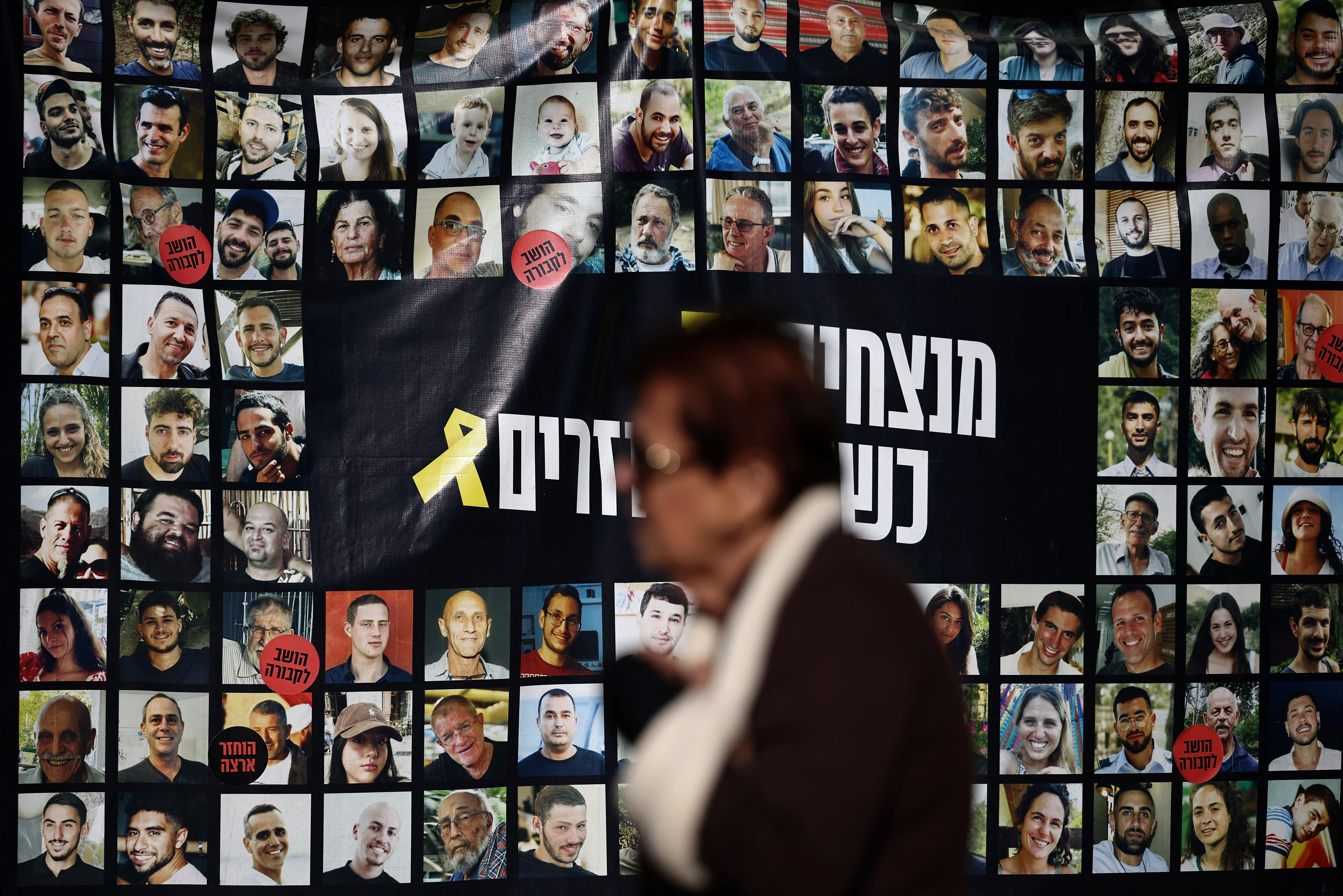 FILE PHOTO: Woman walks past posters of hostages kidnapped during the deadly October 7 2023 attack by Hamas, in Tel Aviv
