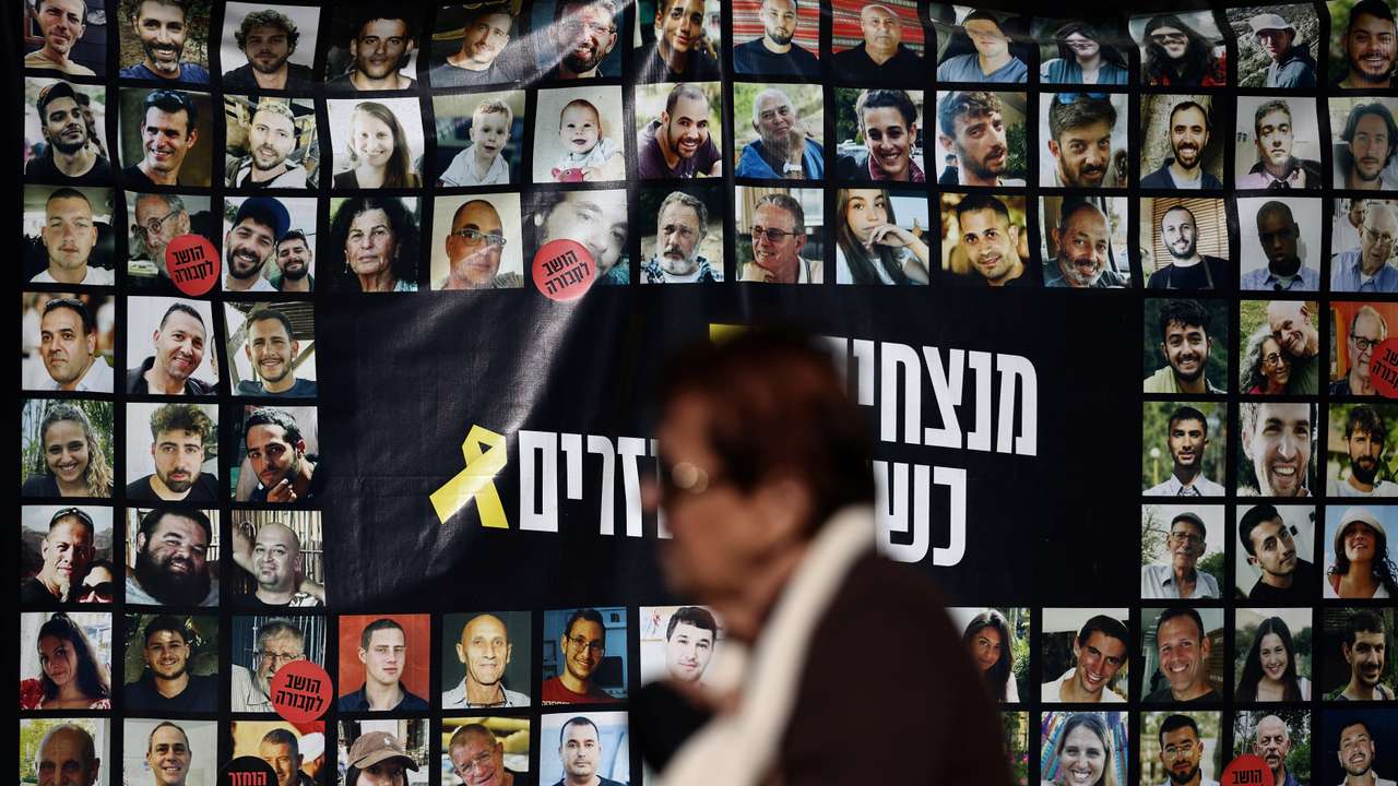 FILE PHOTO: Woman walks past posters of hostages kidnapped during the deadly October 7 2023 attack by Hamas, in Tel Aviv