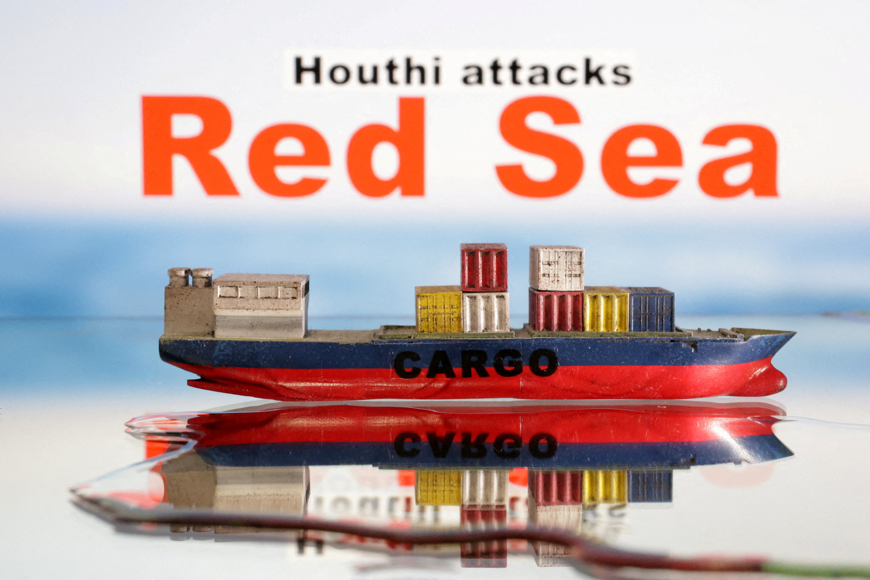 FILE PHOTO: Illustration shows a cargo ship boat model and "Red Sea" and "Houthi attacks" words