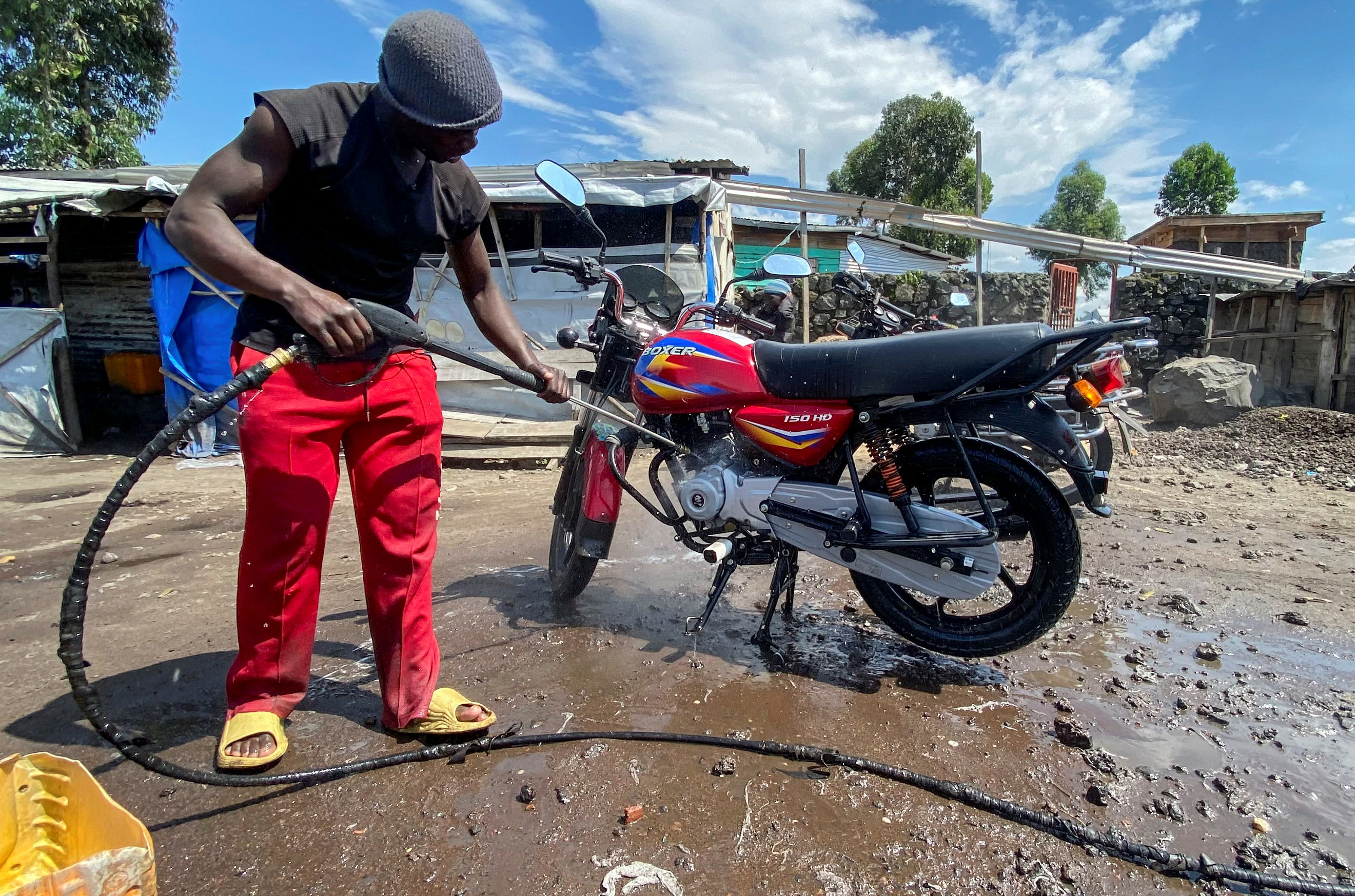 Ishara Bahati Yassin works at his motorbike washing bay business, in Munigi, near Goma