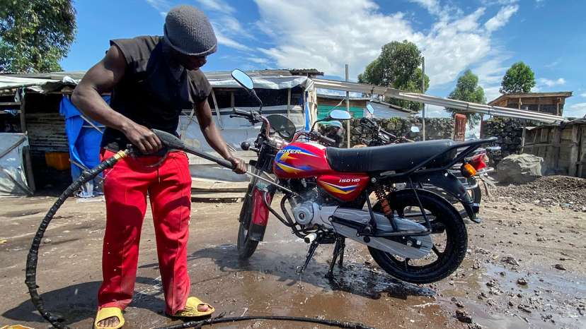 Ishara Bahati Yassin works at his motorbike washing bay business, in Munigi, near Goma