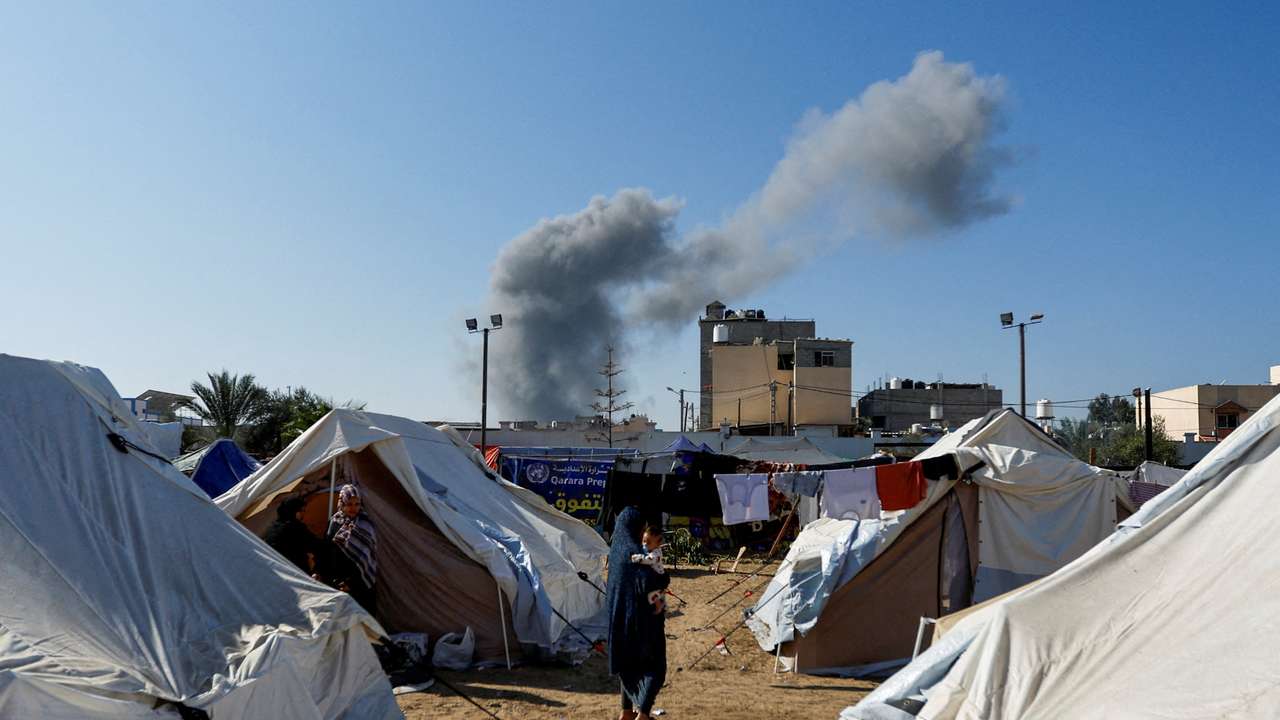 Smoke rises from nearby Israeli strikes as seen from a tent camp sheltering displaced Palestinians, in Khan Younis