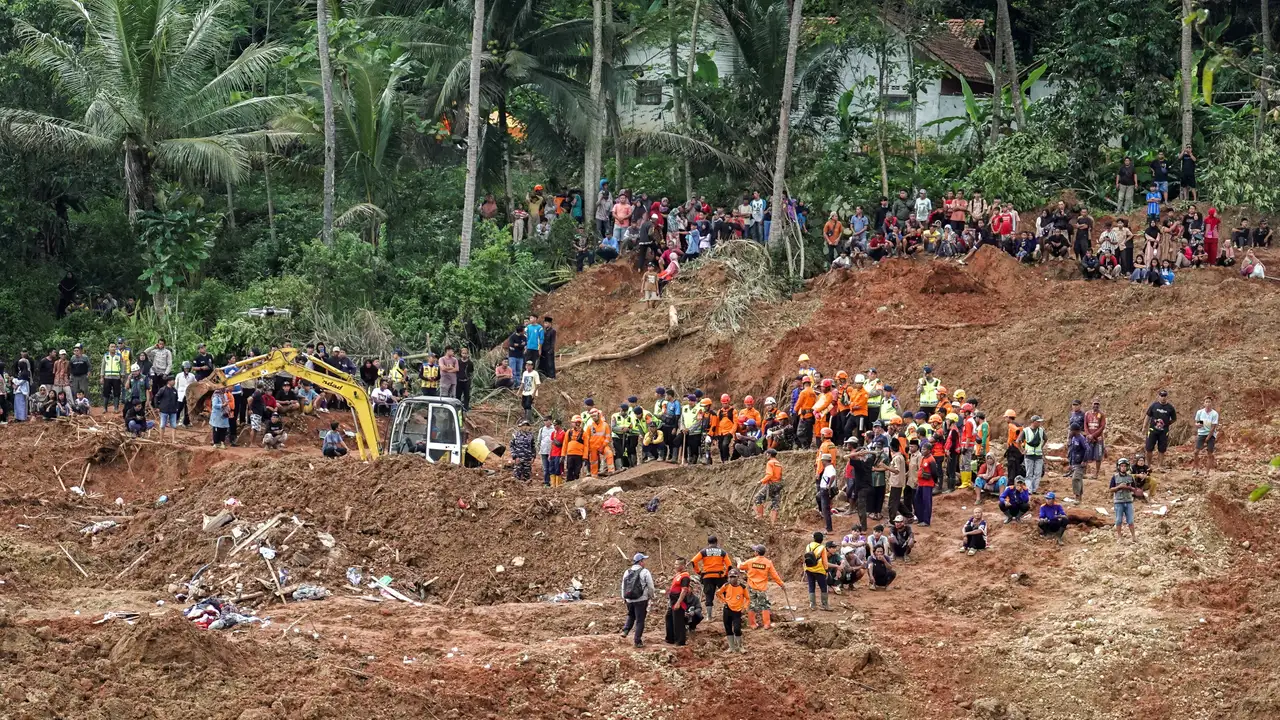 Indonesian rescue members search for victims at the site of a landslide, which hit Cibeunying village on November 13, in Cilacap