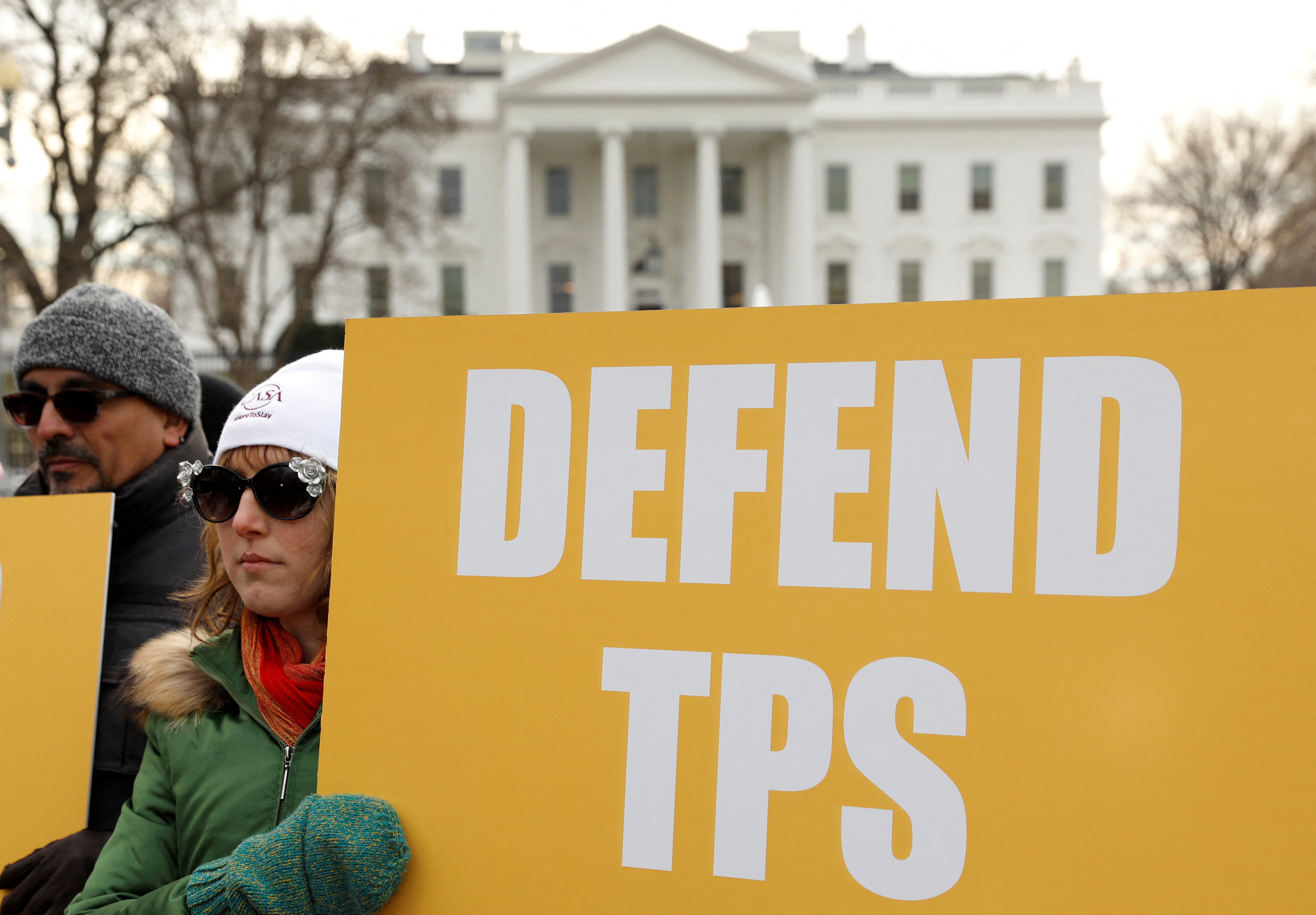 FILE PHOTO: Demonstrators hold signs advocating for Temporary Protected Status