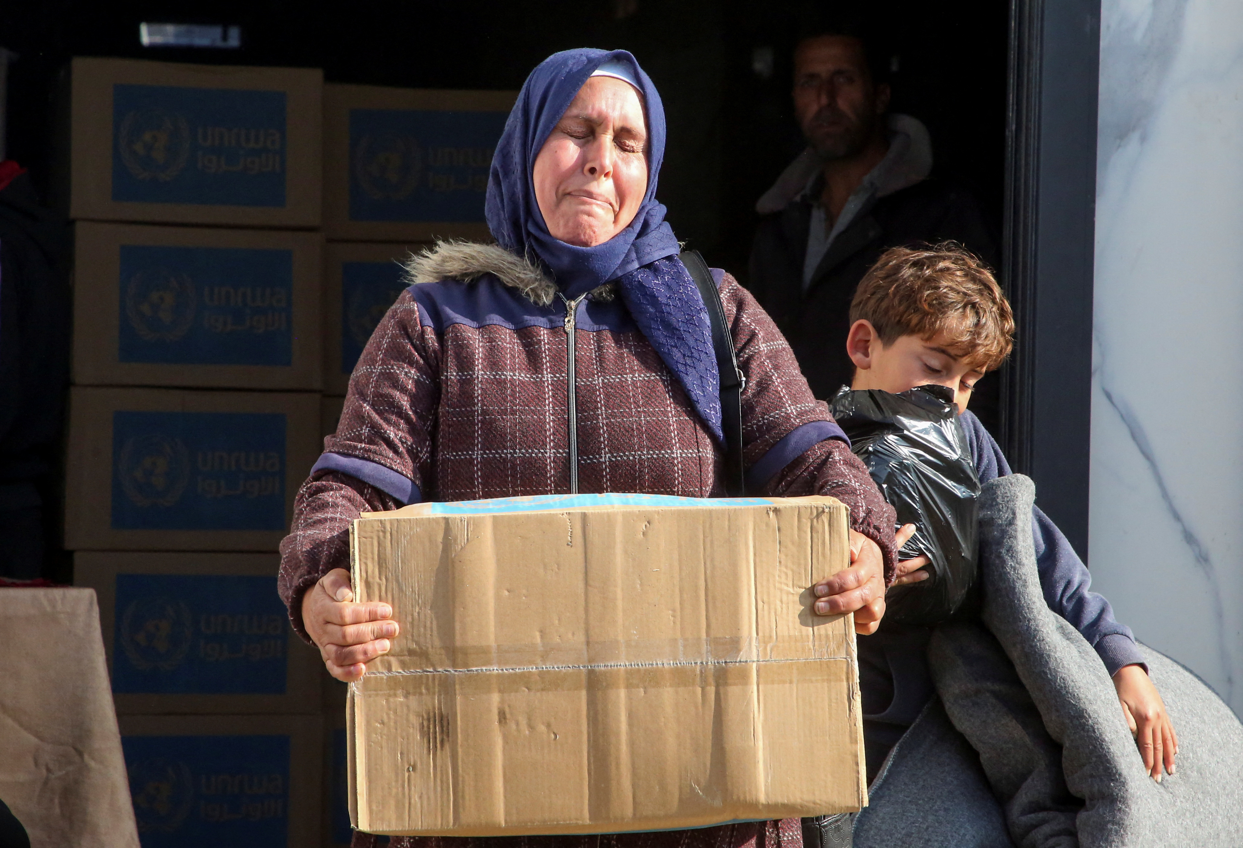 Palestinians receive aid from UNRWA in Khan Younis in the southern Gaza Strip