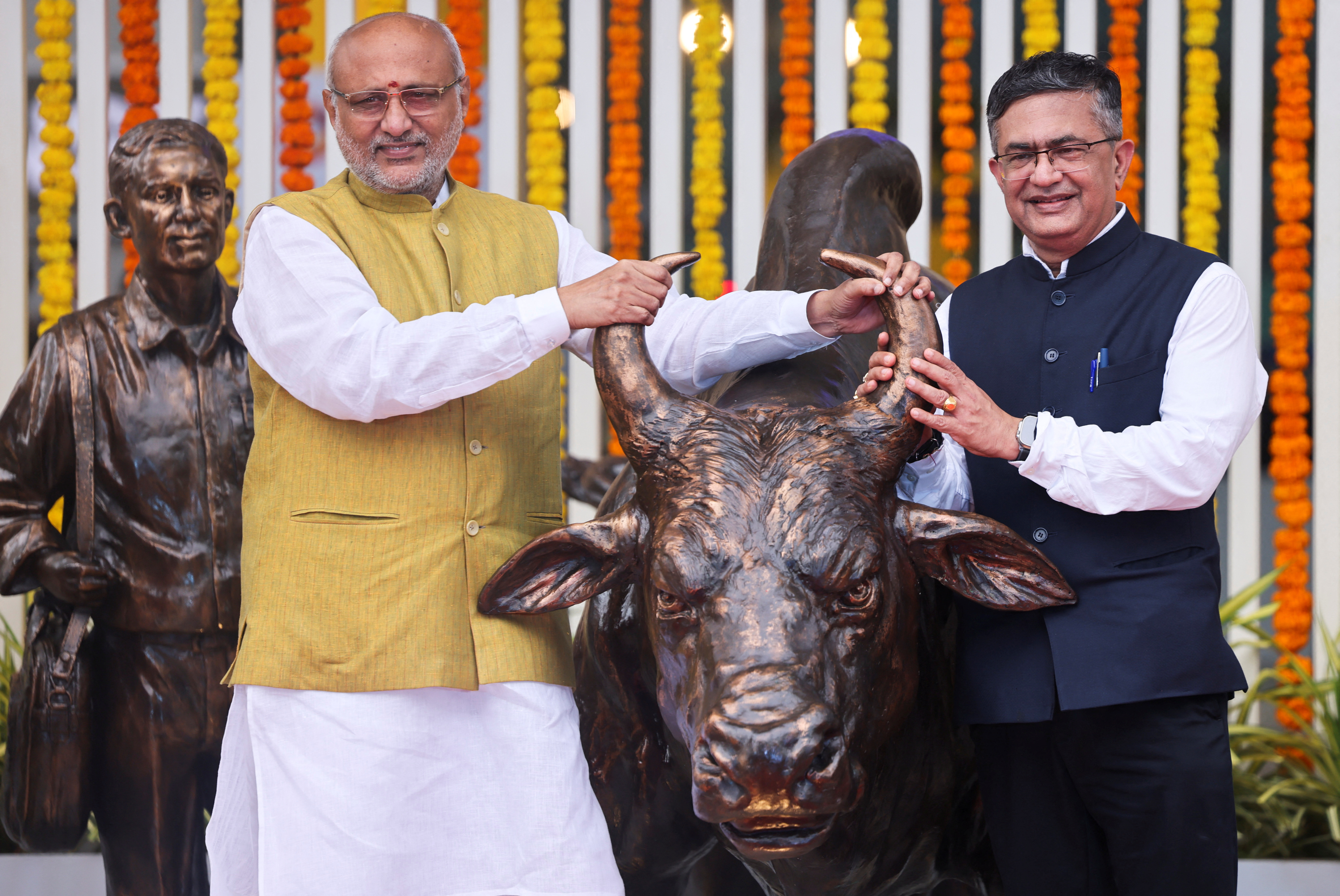 Governor of Maharashtra CP Radhakrishnan and MD and CEO National Stock Exchange (NSE) Ashish Chauhan pose for pictures at the inauguration of the bull statue at the National Stock Exchange (NSE), in Mumbai