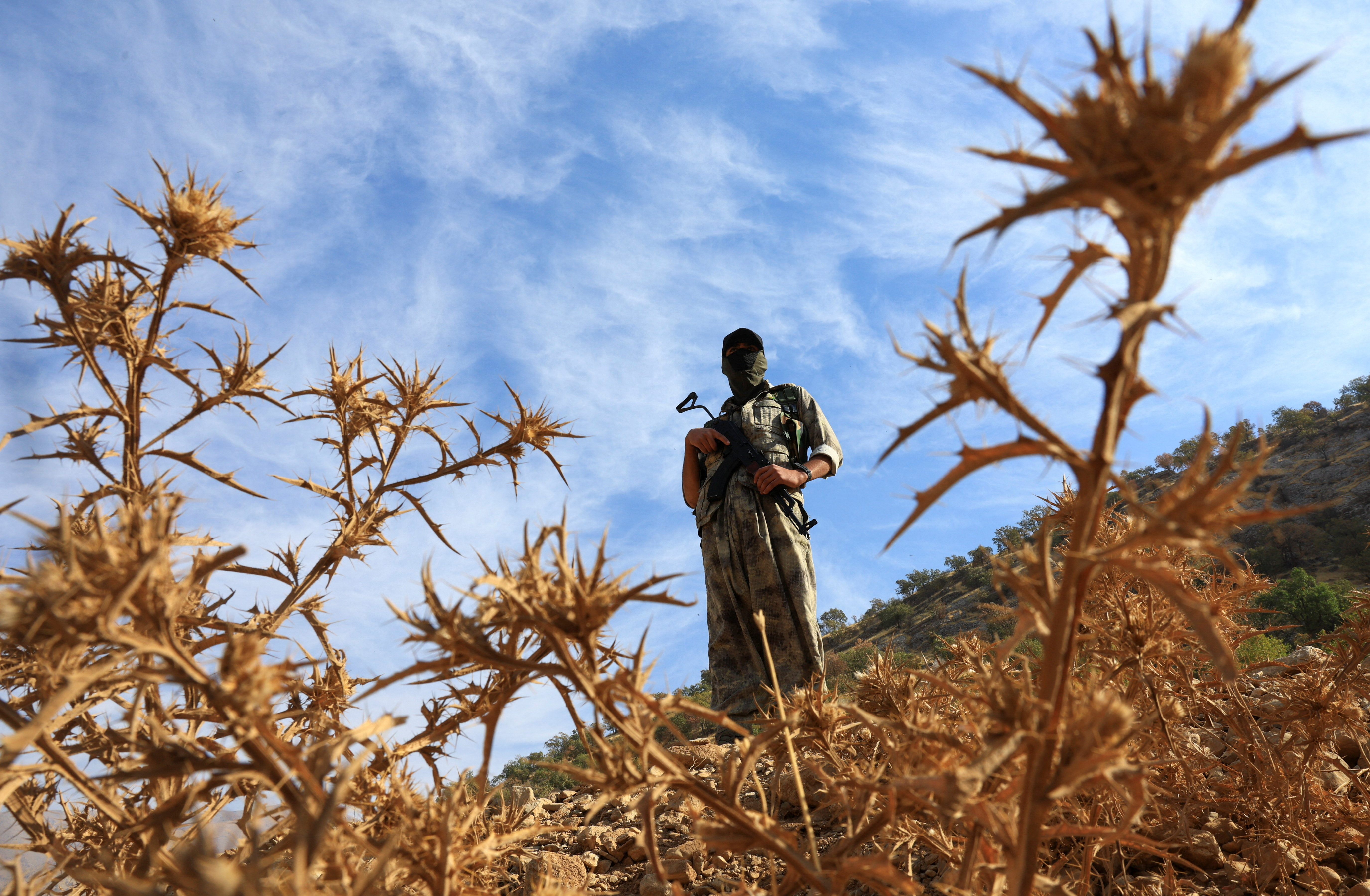 A fighter with the Kurdistan Workers' Party (PKK) stands guard in the Qandil mountains