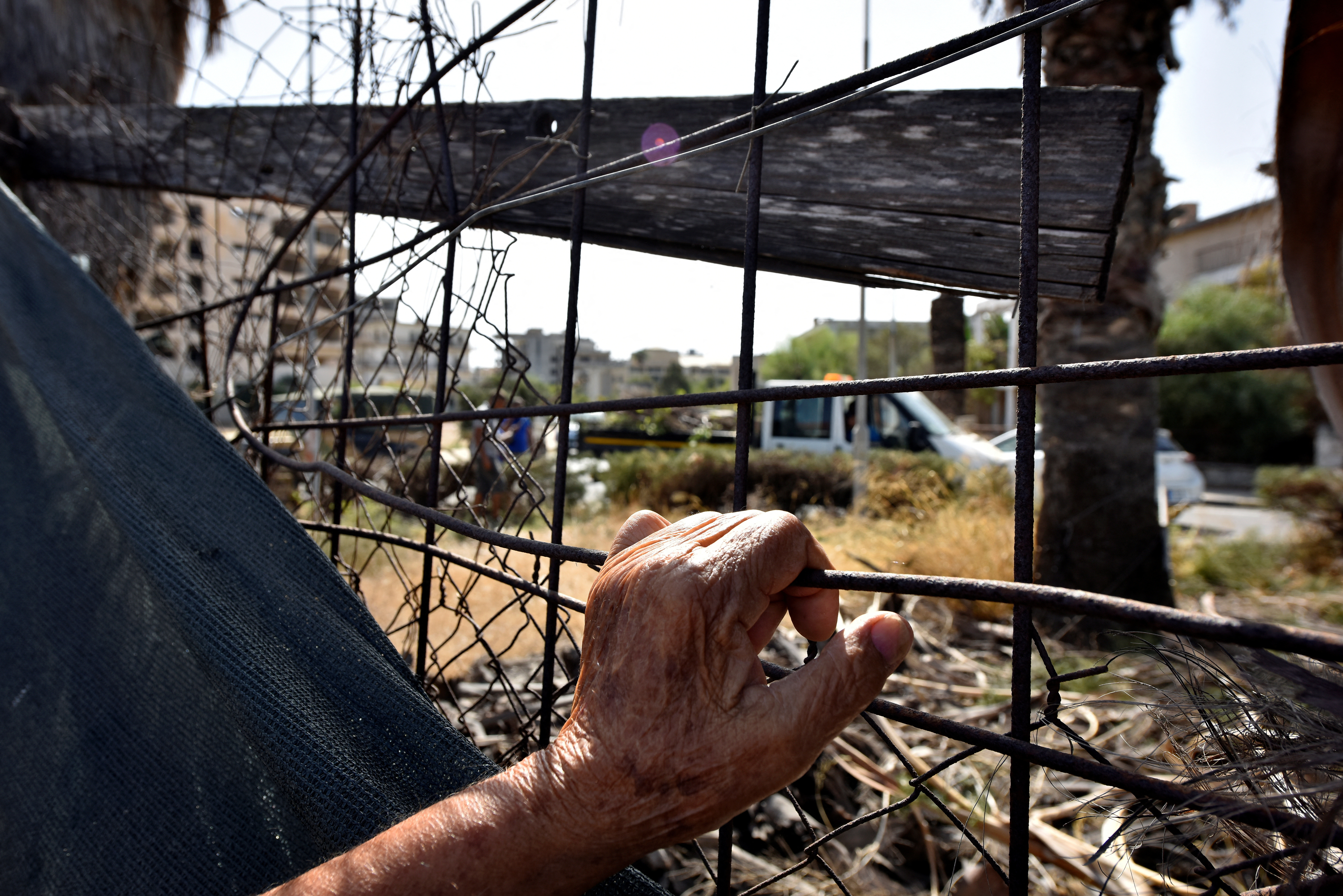 FILE PHOTO: A man holds a fence in the abandoned coastal area of Varosha