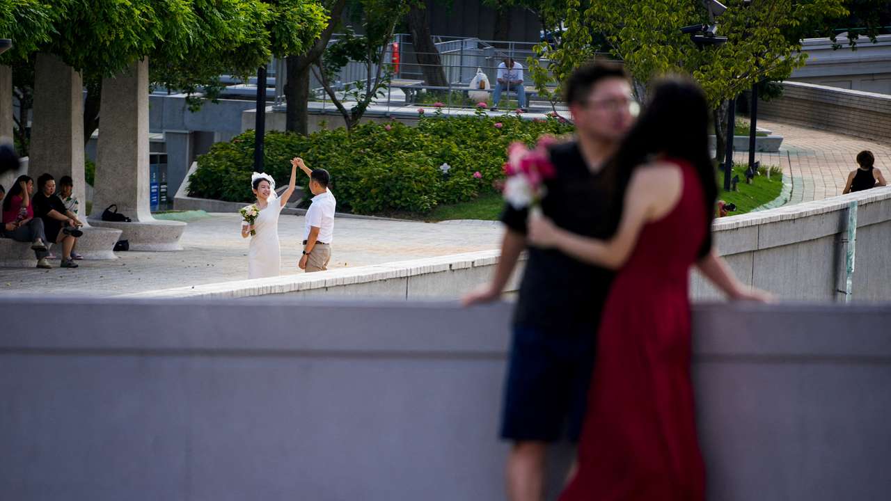 FILE PHOTO: Couples prepare to get their photo taken during a wedding photography shoot on a street, in Shanghai
