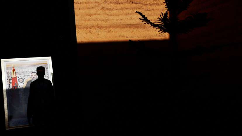 A man walks past an image of Morocco's King Mohammed VI on the first day of the annual meeting of the International Monetary Fund and the World Bank, in Marrakech