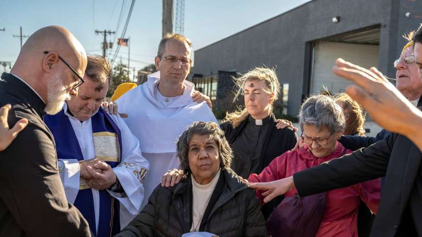 Faithful pray over two priests and a nun before they deliver communion and ashes to people detained in an immigration detention facility, in Broadview