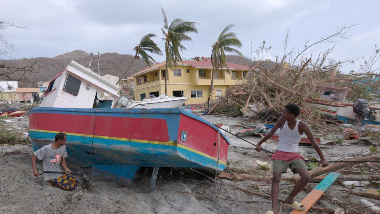 A man digs out a stranded boat after Hurricane Beryl passed the island of Petite Martinique