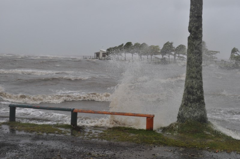 A house is seen as strong waves caused by Cyclone Evan wash a beach in Queen Elizabeth Drive, in Suva