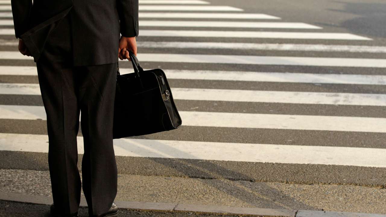 A businessman waits to cross a street in Tokyo