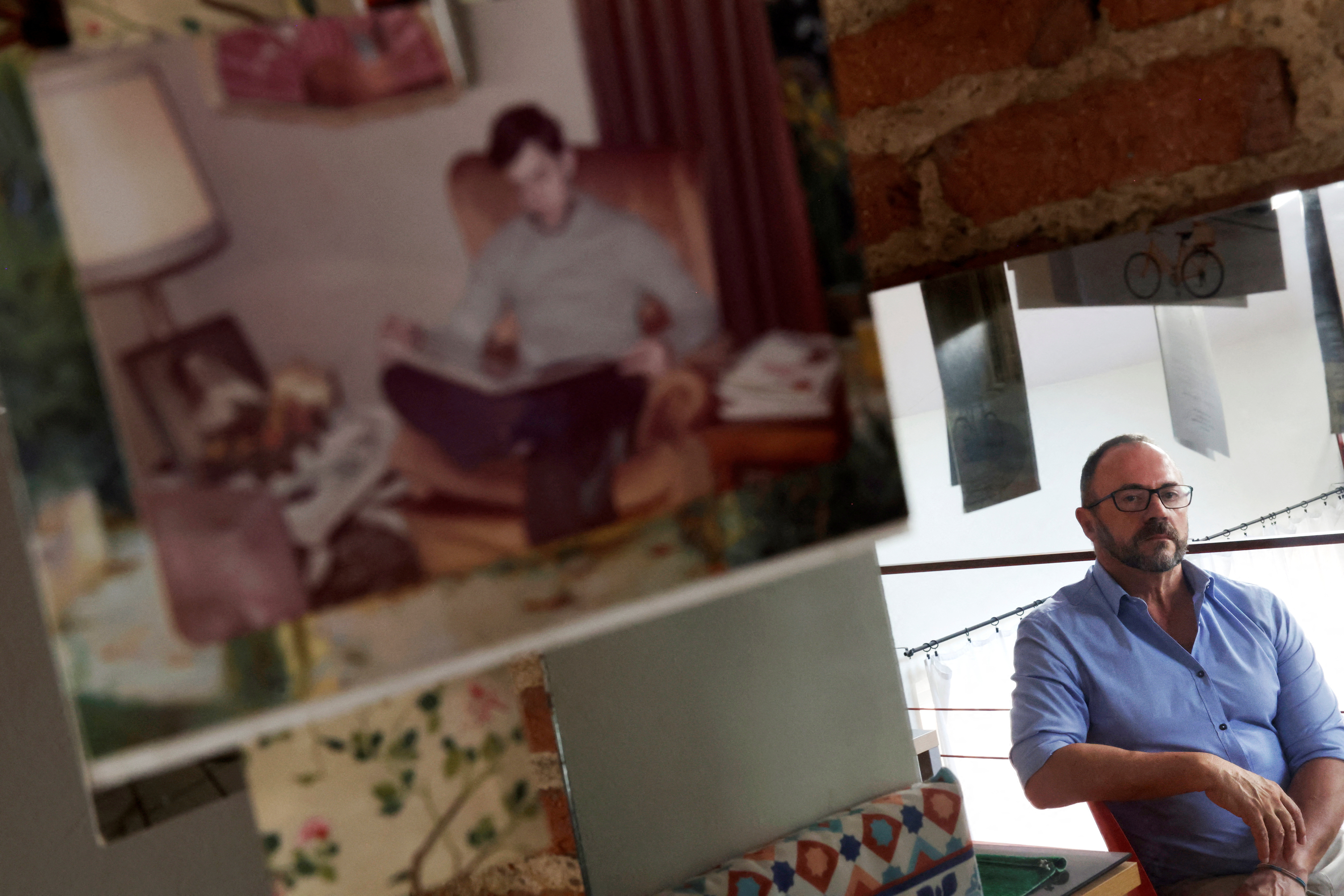 Garcia-Salmones poses at his home next to a picture of himself at the age when he says he was raped by a priest from his school in Madrid