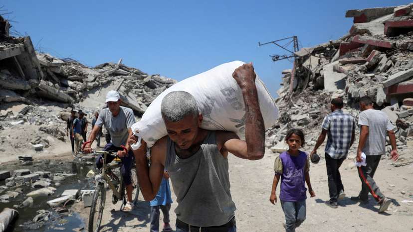 Palestinians carry aid supplies that entered Gaza through Israel, in Beit Lahia