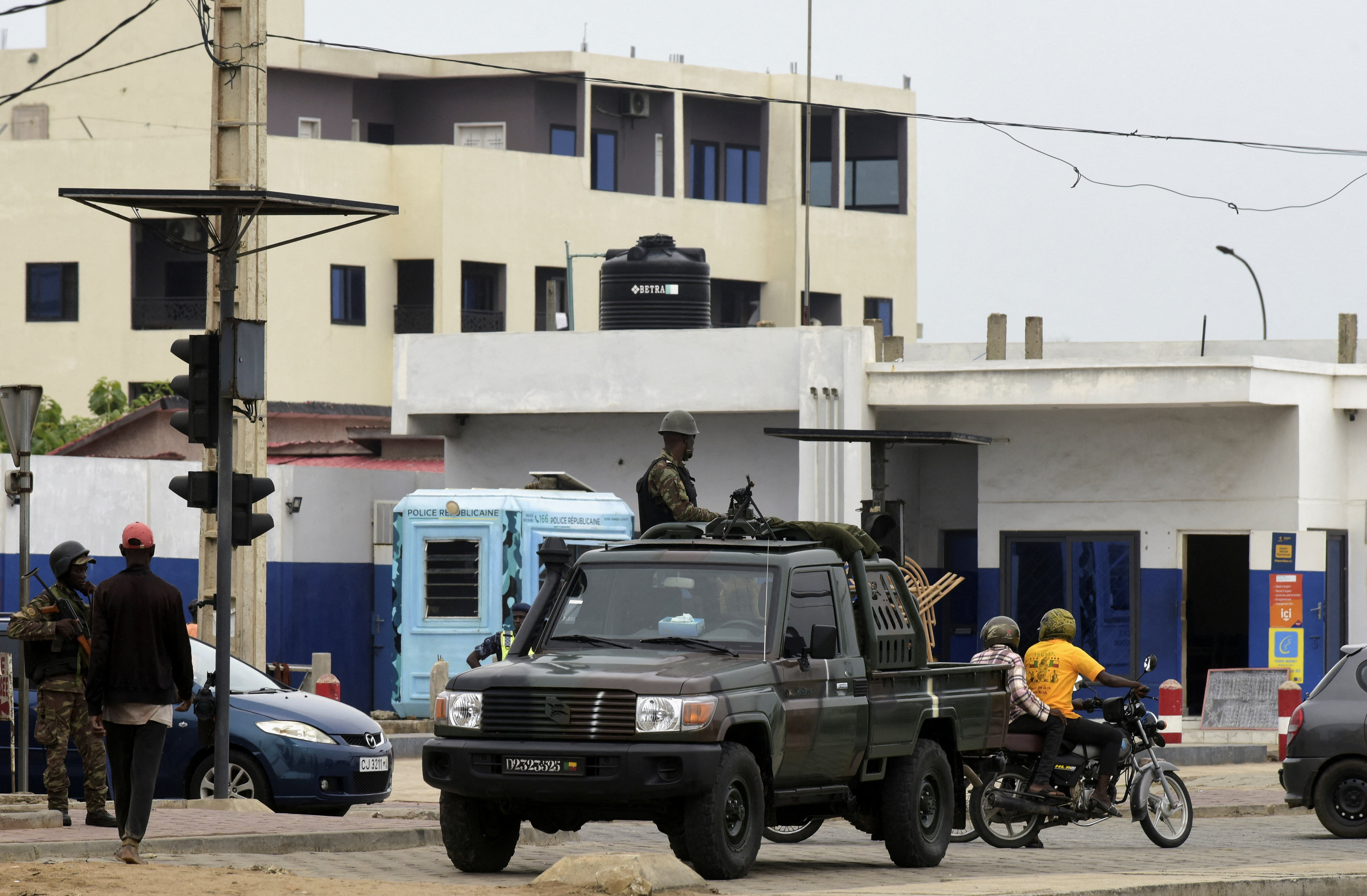 Military vehicles take position, in a street in Cotonou