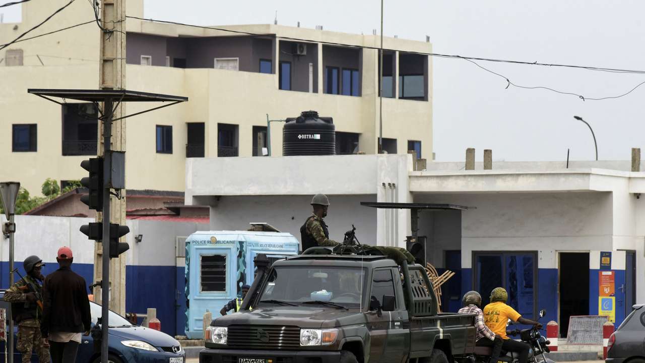 Military vehicles take position, in a street in Cotonou