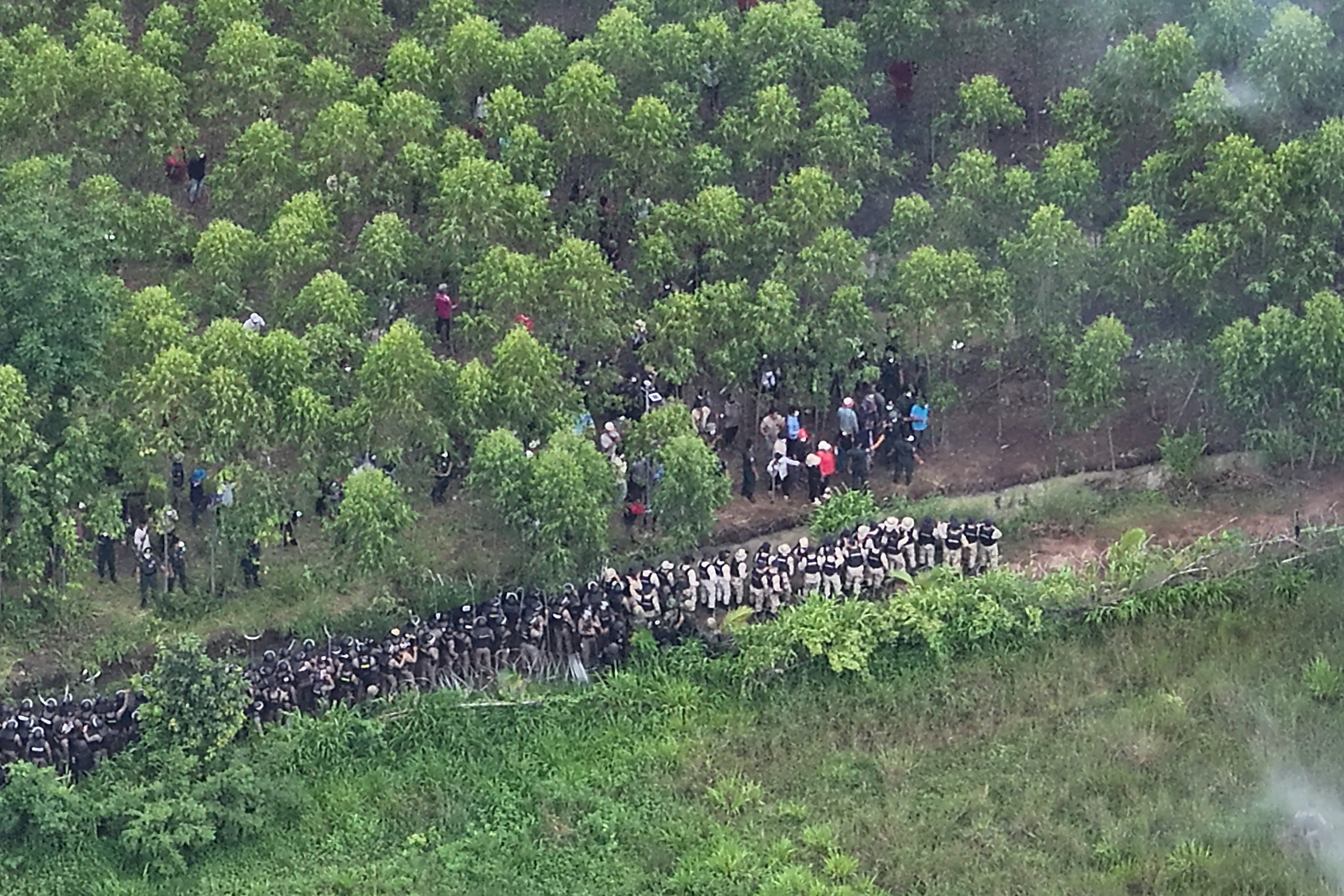 A drone view shows Thai soldiers and riot police officers confronting Cambodian people in a disputed village along the Thailand-Cambodia border in Sa Kaeo province