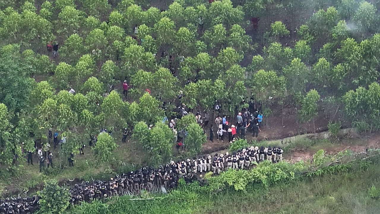A drone view shows Thai soldiers and riot police officers confronting Cambodian people in a disputed village along the Thailand-Cambodia border in Sa Kaeo province