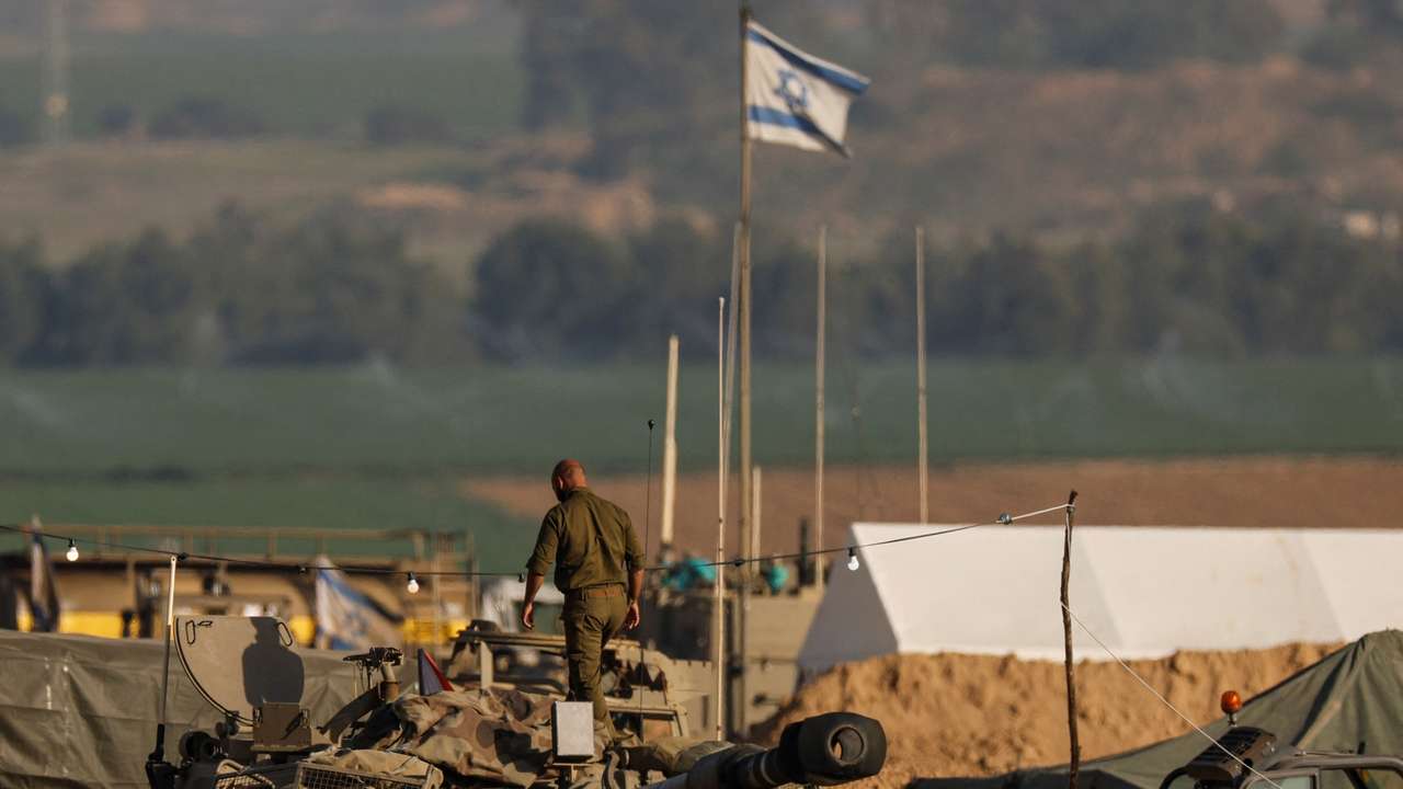 An Israeli solider walks on a mobile artillery unit near the Israel-Gaza border in southern Israel