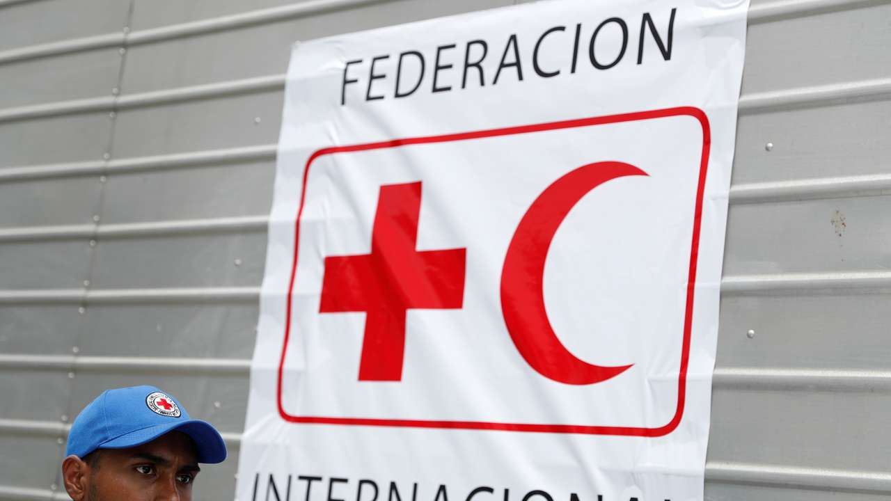 A worker of Venezuelan Red Cross walks past a truck with logo of the International Federation of Red Cross and Red Crescent Societies (IFRC) carrying humanitarian aid, at a warehouse where the aid will be stored, in Caracas