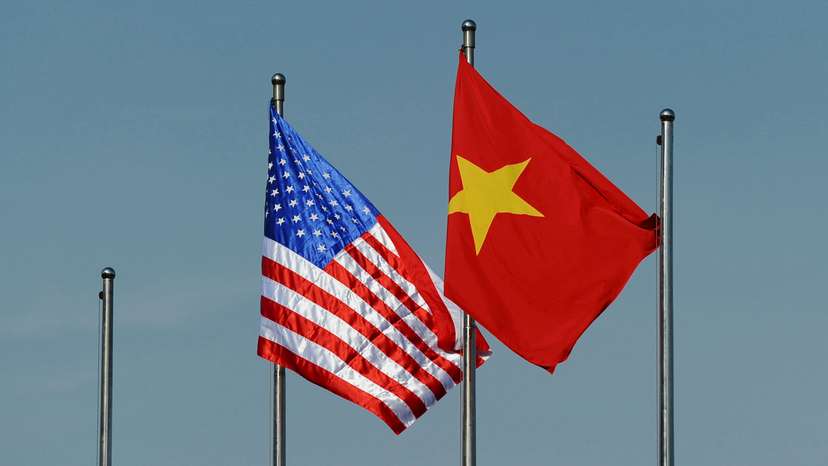 The U.S. flag flutters next to the Vietnamese flag during a welcoming ceremony for U.S. Defense Secretary Ash Carter in Hanoi, Vietnam