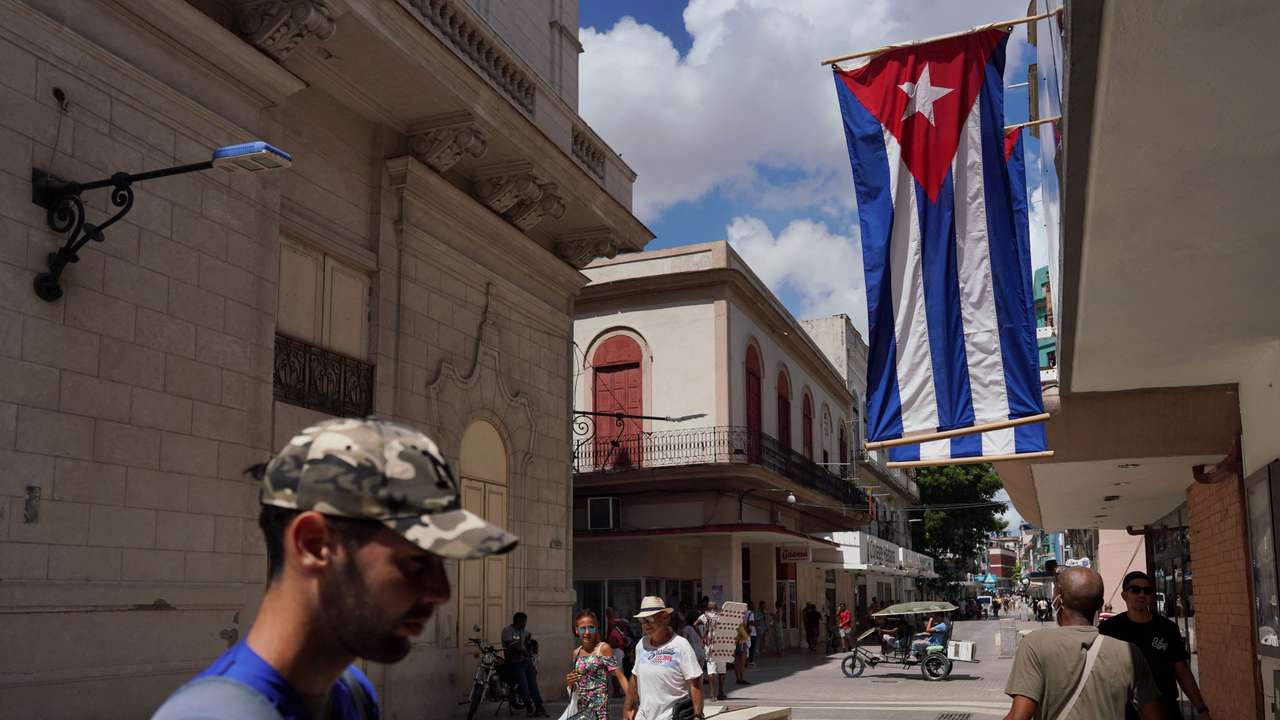 Cuban flags are displayed at a commercial road in Havana