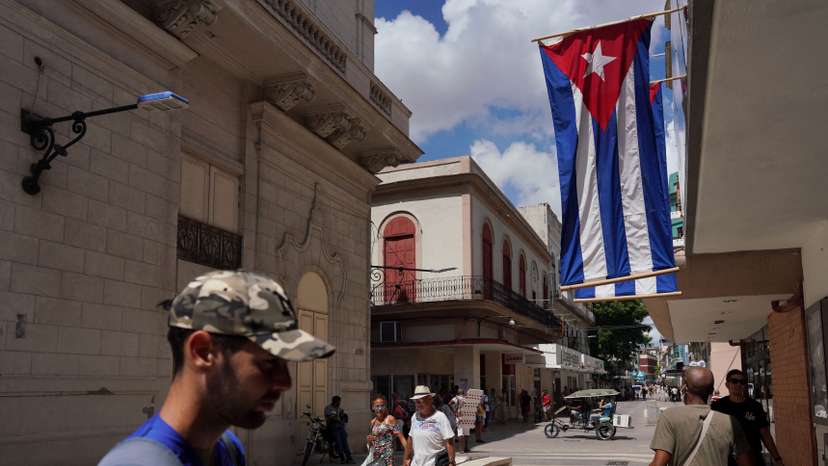 Cuban flags are displayed at a commercial road in Havana